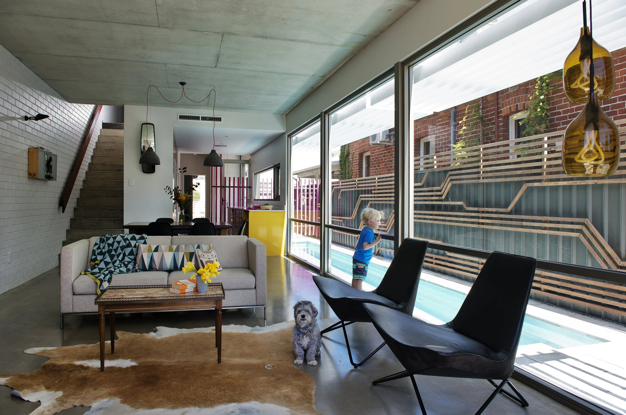 Florence St. A family approached us to select a site for their inner-city home. Its long side faces north and abuts a heritage semi-detached creating an opportunity to maintain access to north light. The design is a marriage of utilitarian functionalism with tongue-in-cheek playfulness. The planning of the building is simplistic and efficient. Materials selected are honest and expressed genuinely. The spaces address the light and the outdoor areas and each of the four bedrooms has its own unique urban aspect. A long lap-pool inhabits the space between the house and its neighbour and brings reflected diffuse light into the home and creates a sense of separation. A recurring theme for the building and for which the building has become somewhat known is the inclusion of repeating space invader sprite from the 80’s computer game. I liked the idea of connecting the element of the brick to the pixel of computer design and explored this simplistically in this building. The clients’ are kids of the eighties and enjoy the reference. The building is a tight infill project that makes the most of a small site and celebrates its materials and the urban environment it inhabits in an honest and playful way.