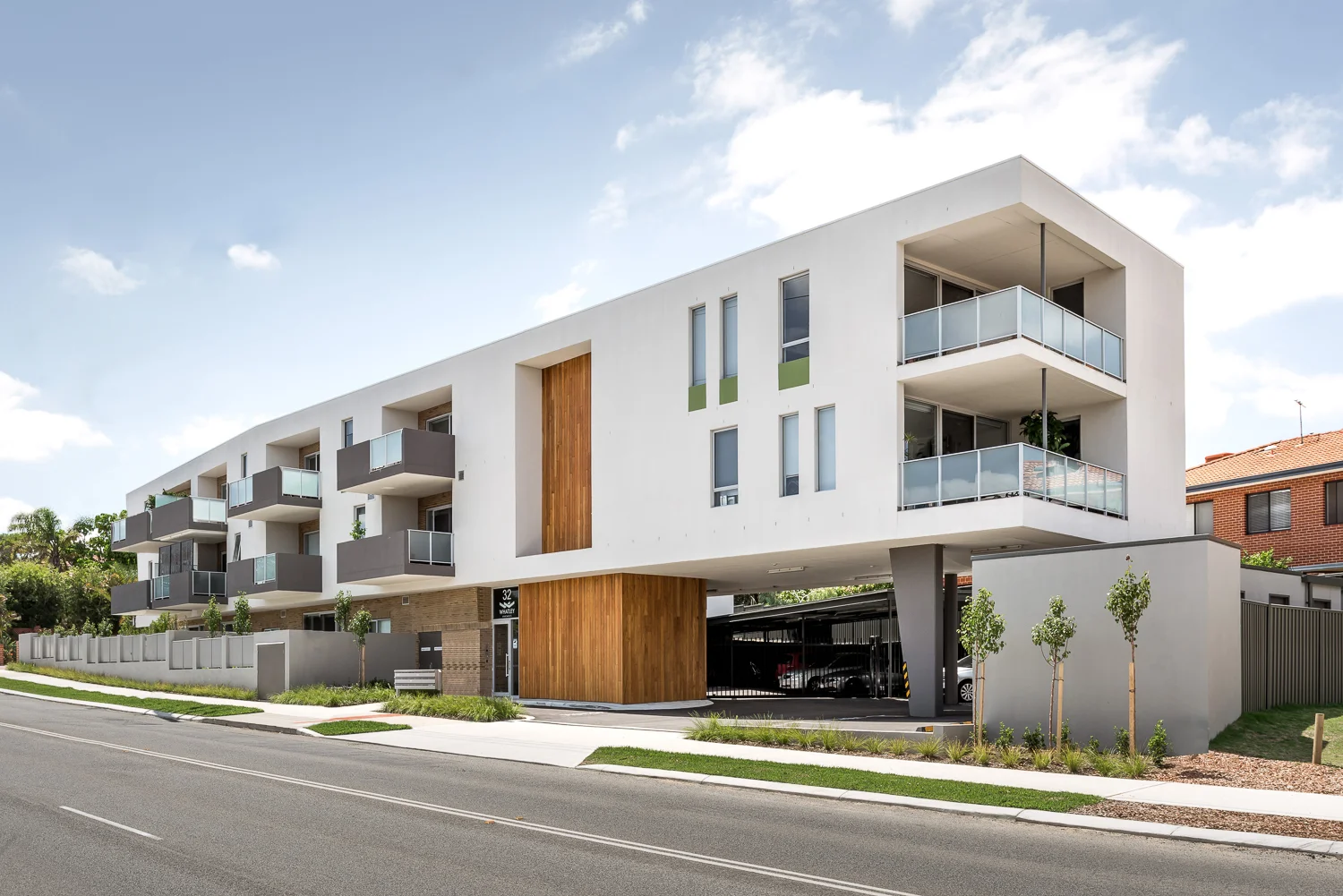 Whatley A simple and elegant design on a complex site. This site included a series of easements, conditions and constraints which significantly influences the design of the building and the location of outdoor spaces and detailing. The solution required consultation with Western power over a three-dimensional easement formed by the arc of a wet power lines in extreme winds and included the civil works for a sewer realignment and manhole recommissioning. The triangular site tapers on two ends with a fatter middle, the longest side was contiguously piled to deal with 5 adjacent lower zoned neighbours and includes a sewer easement and man hole. Traffic stacking and movement was also a critical design consideration which influenced the design of the entry spaces. The upper levels of the building folds around the broad point of a tapering power easement. The base is face brick, referencing domestic construction and forms the straight line which expresses the folded form over. The upper levels continue to soar over an entry space, elevating these apartments away from the street and the rail line and creating a dynamic building form that faces the street. A warm timber element creates a strong entry space and draws the tenants and visitors into an entrance lobby level. The front courtyards are raised slightly from the street to provide privacy and reduce noise to these lower level apartments. The complexity of the site, the cost of civil works, easement protection and traffic management have all been integrated into a successfully delivered commercial outcome and $2,700 /m² represents excellent value for money for this project. The project included a remarkable efficiency through minimising common area which was necessitated by the complex site and conditions. The typical floor includes common area of 33m² which serves 760m² of gross floor area, or 650m² of saleable area, representing 5% of a typical floor plate. Coordination with the consultants lead to a successful and painless delivery of the project which this included a forward works civil package and concurrent approvals with council and Western Power. The orientation of Mt Lawley blocks leads to difficulties in delivering good access to North light for most of the apartments, particularly on this unusually shaped block, with only a short side facing North and the longest side (away from the R20 housing) facing directly West. Despite these significant constraints, the apartments achieved an average NatHERS rating of 7.4, with the highest rating of 9.3. We believe this to be an excellent result. The completed project is a gateway to a re-invigorated Bayswater precinct. The council supported the development, and its significant concession to planning requirements, as they saw the opportunity and delivery of an iconic sculptural form at this threshold entry. The building successfully delivers on the faith placed by the local authority in this project. PROJECT SUMMARY A simple and elegant design on a complex site. The upper levels of the building folds around the broad point of a tapering power easement. The base is face brick, referencing domestic construction and forms the straight line which expresses the folded form over. The upper levels continue to soar over an entry space, elevating these apartments away from the street and the rail line and creating a dynamic building form that faces the street. A warm timber element creates a strong entry space and draws the tenants and visitors into an entrance lobby level. The completed project is a gateway to a re-invigorated Bayswater precinct. The council supported the development, and its significant concession to planning requirements, as they saw the opportunity and delivery of an iconic sculptural form at this threshold entry. The building successfully delivers on the faith placed by the local authority in this project. 