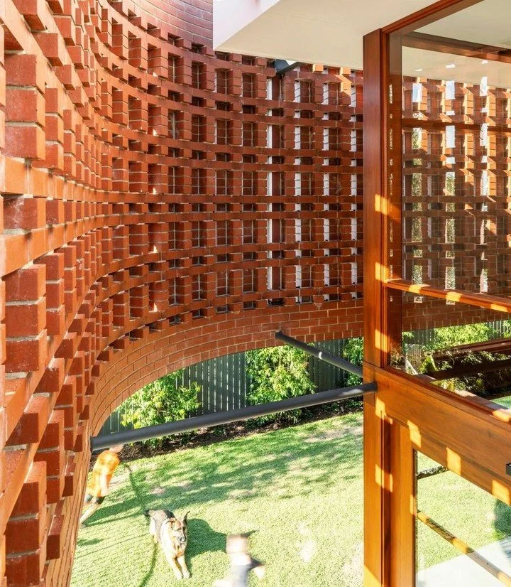 A curvaceous hit-and-miss brick screen scatters sunlit shadows, filtering harsh western light, enhancing privacy and welcoming cross-ventilation at this inner-city family home.

#redrockbrickworks #architecturalbrickwork #hitandmissbrickwork #bespoke