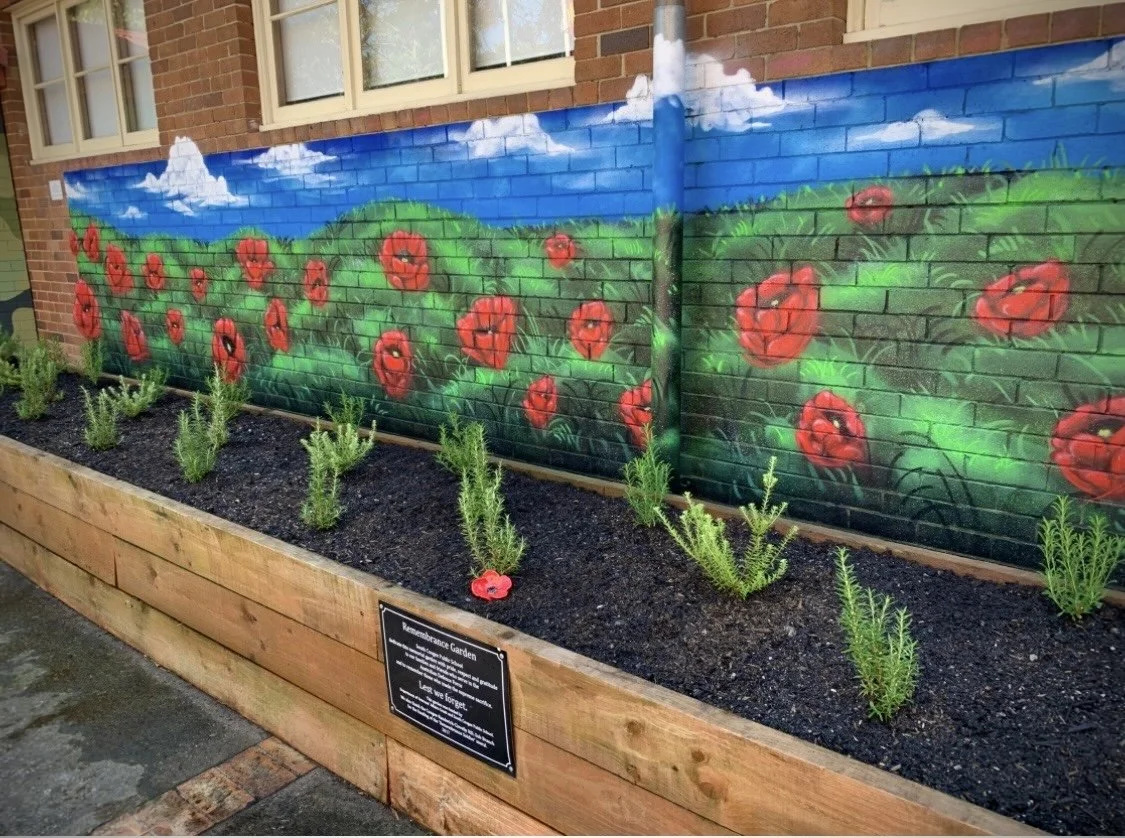 Anzac mural of blue sky and poppy field, painted for South Coogee Public School. 