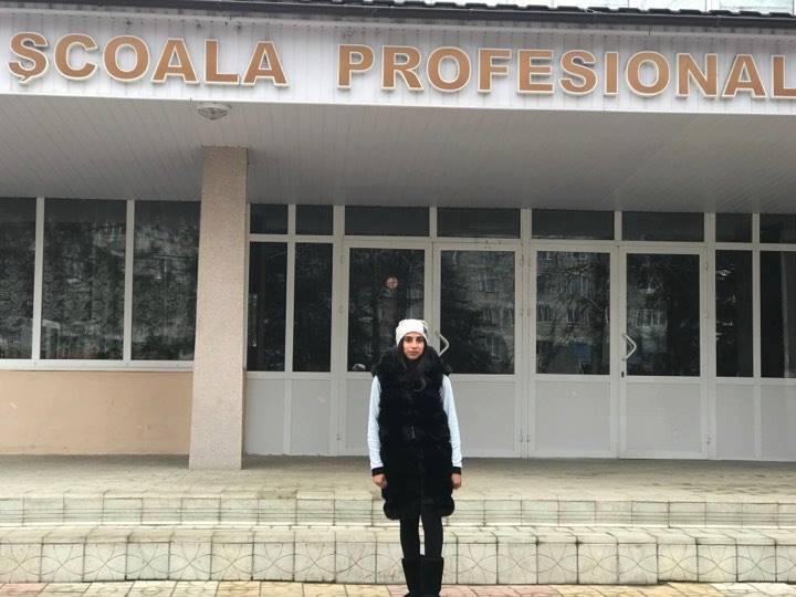Stela poses outside her vocational school.