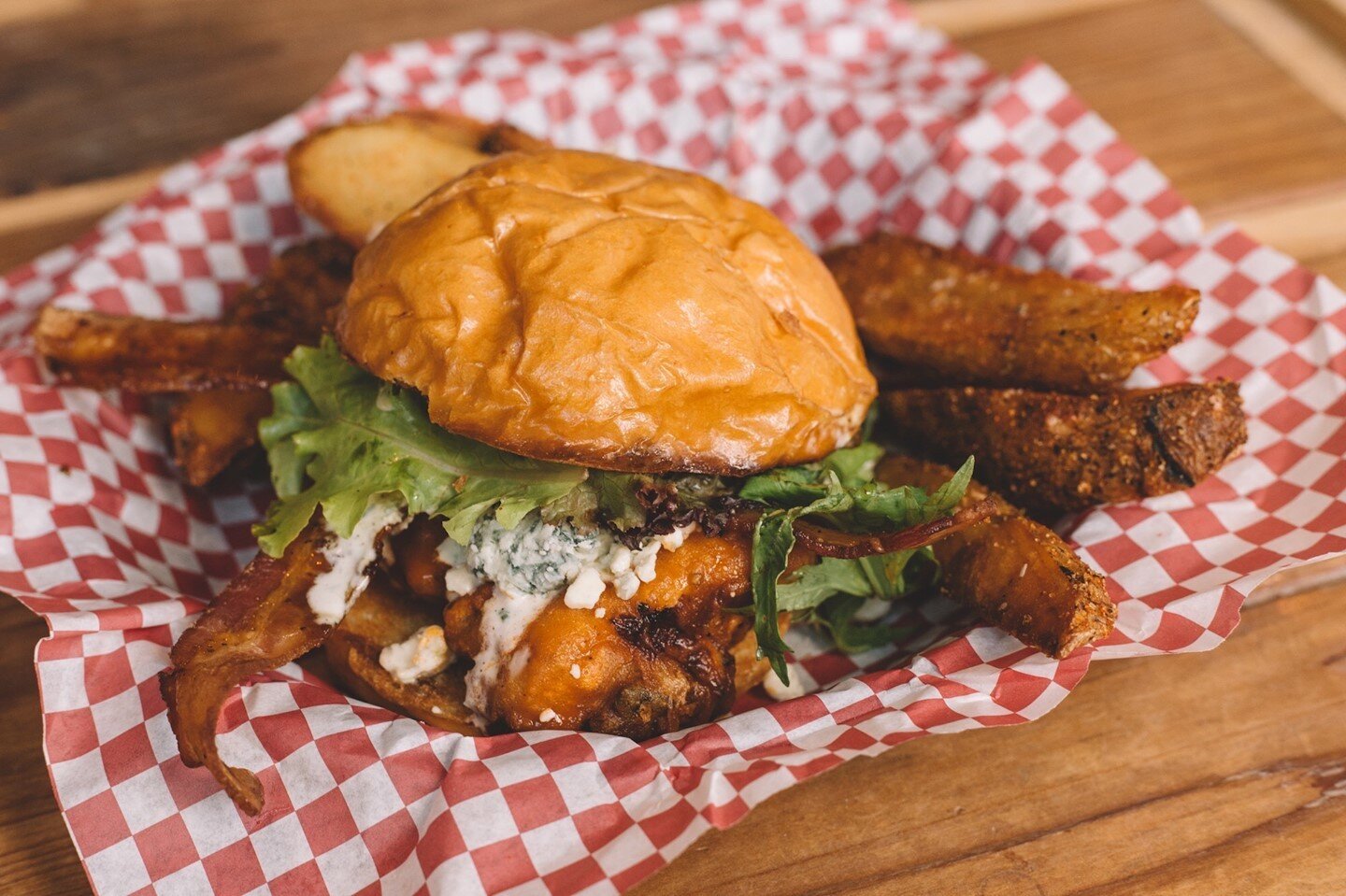 The Buffalo Starchild is one monster of a sandwich. A fried chicken thigh, tossed in buffalo sauce, with blue cheese crumbles and bacon, topped with lettuce and black pepper ranch. Comes with wedges!⁠
.⁠
.⁠
.⁠
#WatsonsShack #Watsons #WatsonsRail #UIU