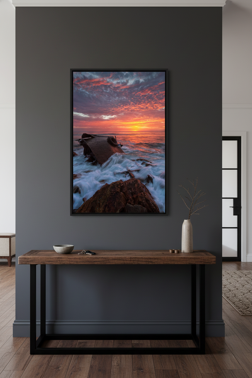 SS Dominator shipwreck sunset print displayed on a charcoal grey accent wall above a wooden entryway console table.