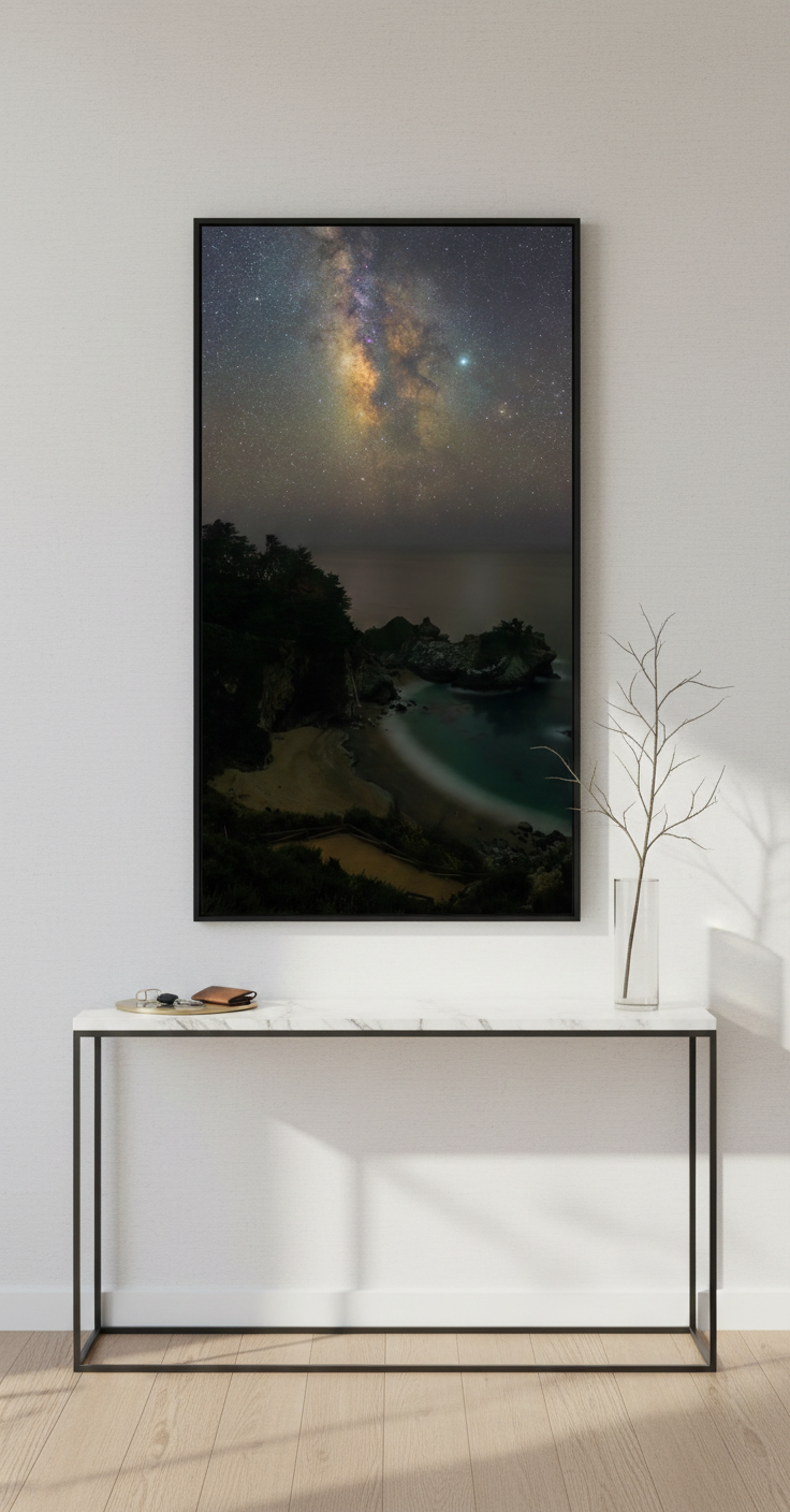 Vertical McWay Falls Milky Way art print in a thin black frame hanging above a minimalist marble entry table.