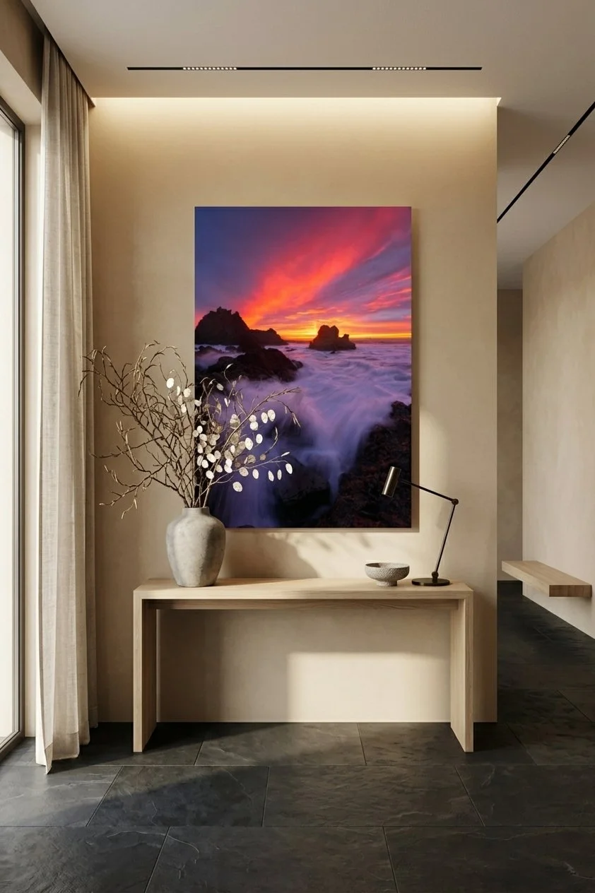 Fine art ocean sunset print resting above a minimalist console table in a bright entryway.