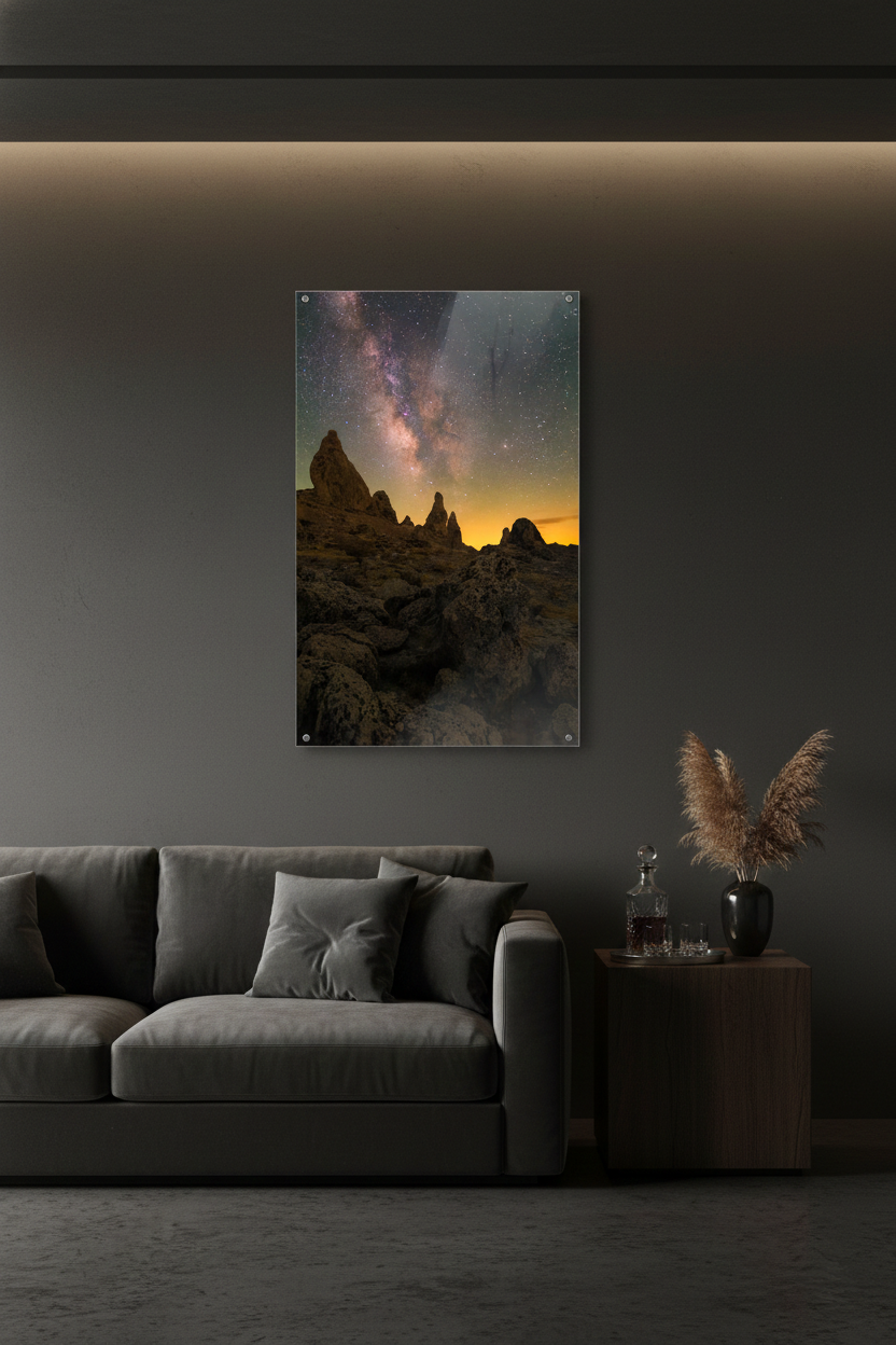 Glossy acrylic print of Trona Pinnacles Milky Way photo hanging on a charcoal grey wall above a velvet sofa in a modern room.