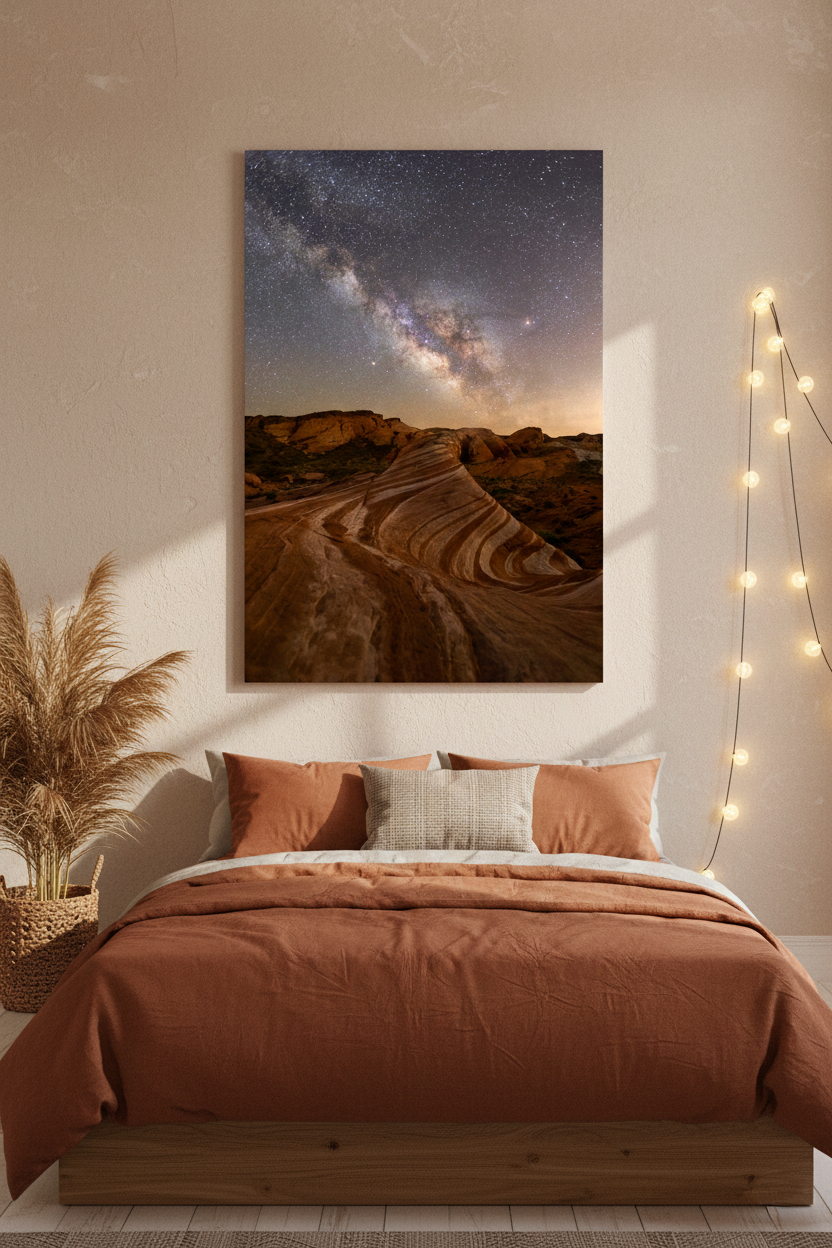 Large vertical fine art print of the Fire Wave Milky Way mounted above a bed with terracotta linen bedding and ambient string lights.