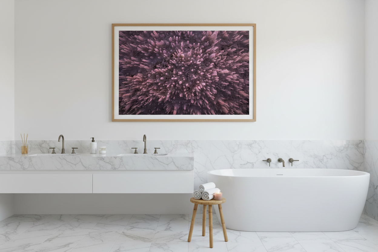 Oversized framed abstract salt crystal artwork mounted on a white wall above a freestanding soaking tub in a white marble bathroom.