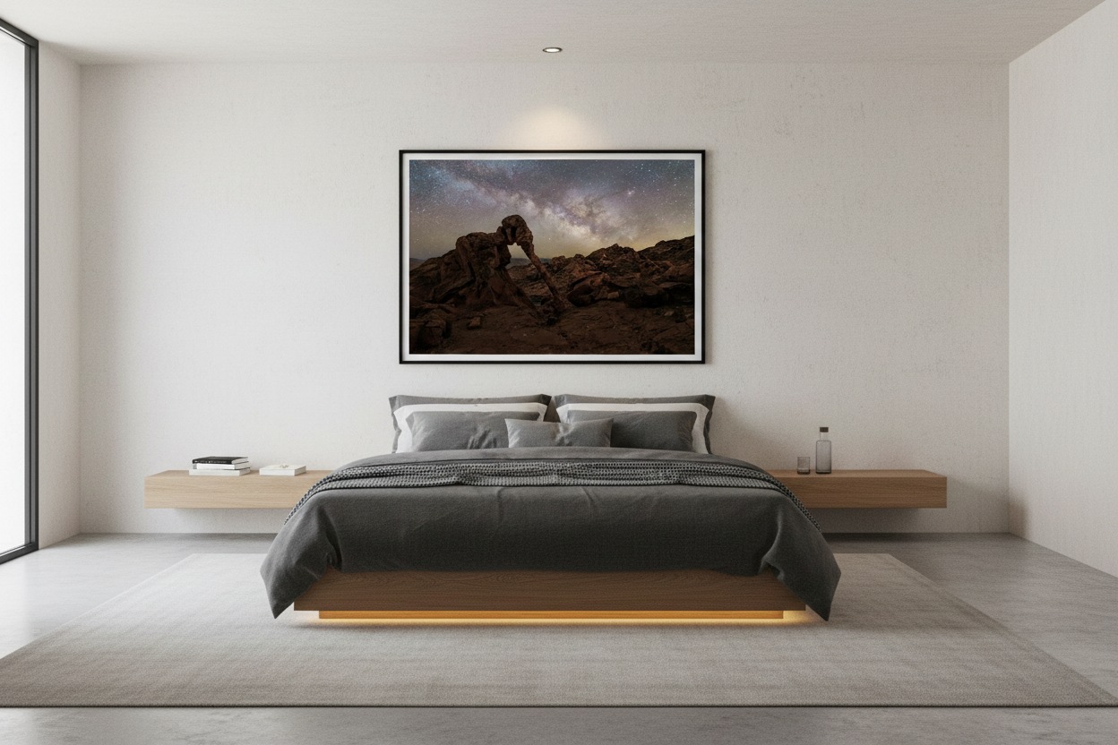 Framed horizontal astrophotography print mounted on a white wall above a low wooden platform bed with charcoal bedding.