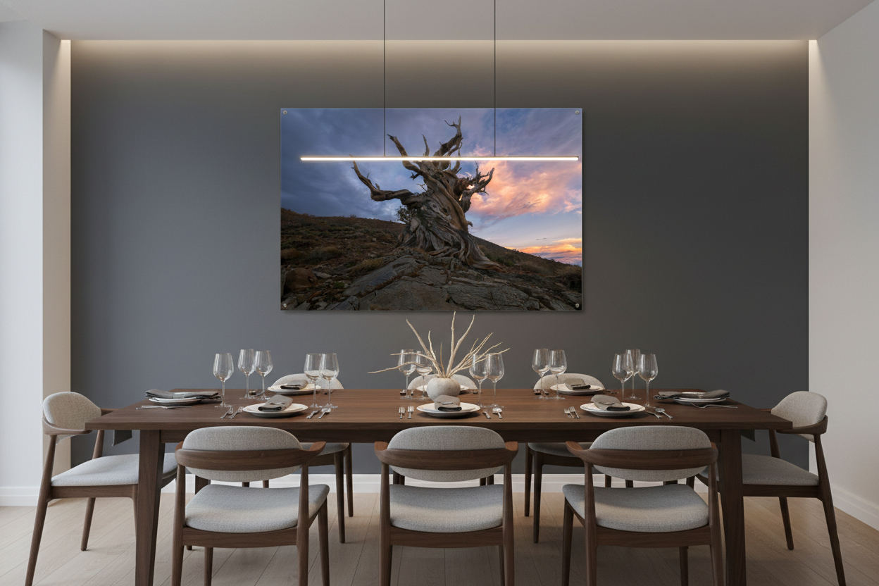Horizontal bristlecone pine dusk landscape photograph mounted on a dark grey accent wall over an elegant modern wooden dining table.