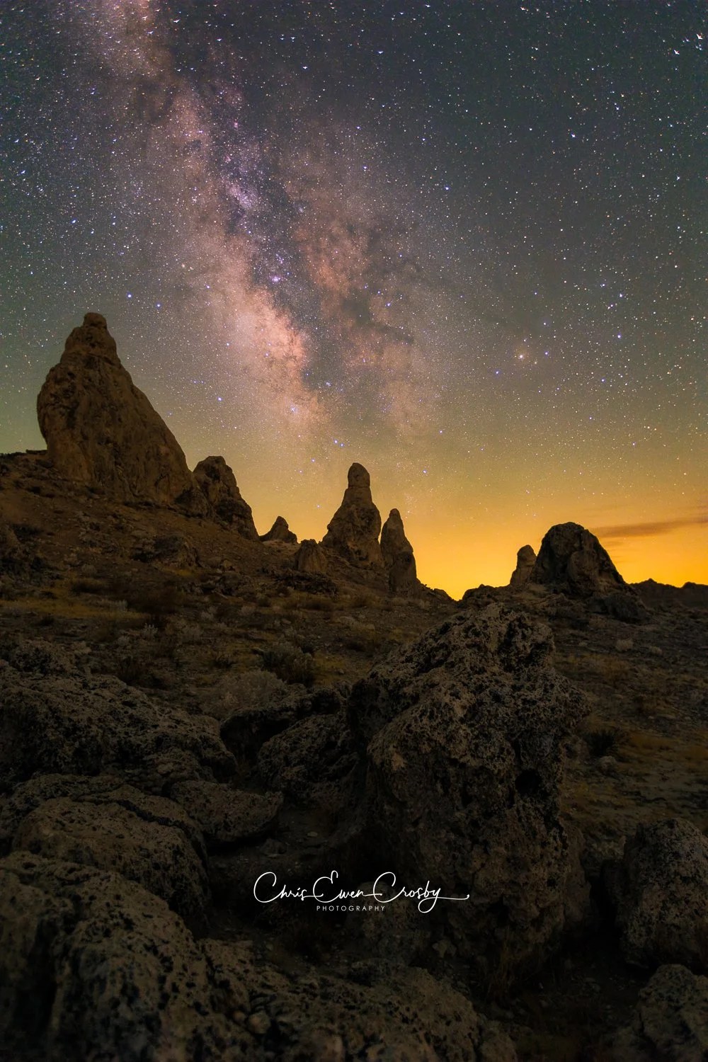 Vertical night photograph of the Milky Way core directly above the jagged tufa spires of Trona Pinnacles in California.