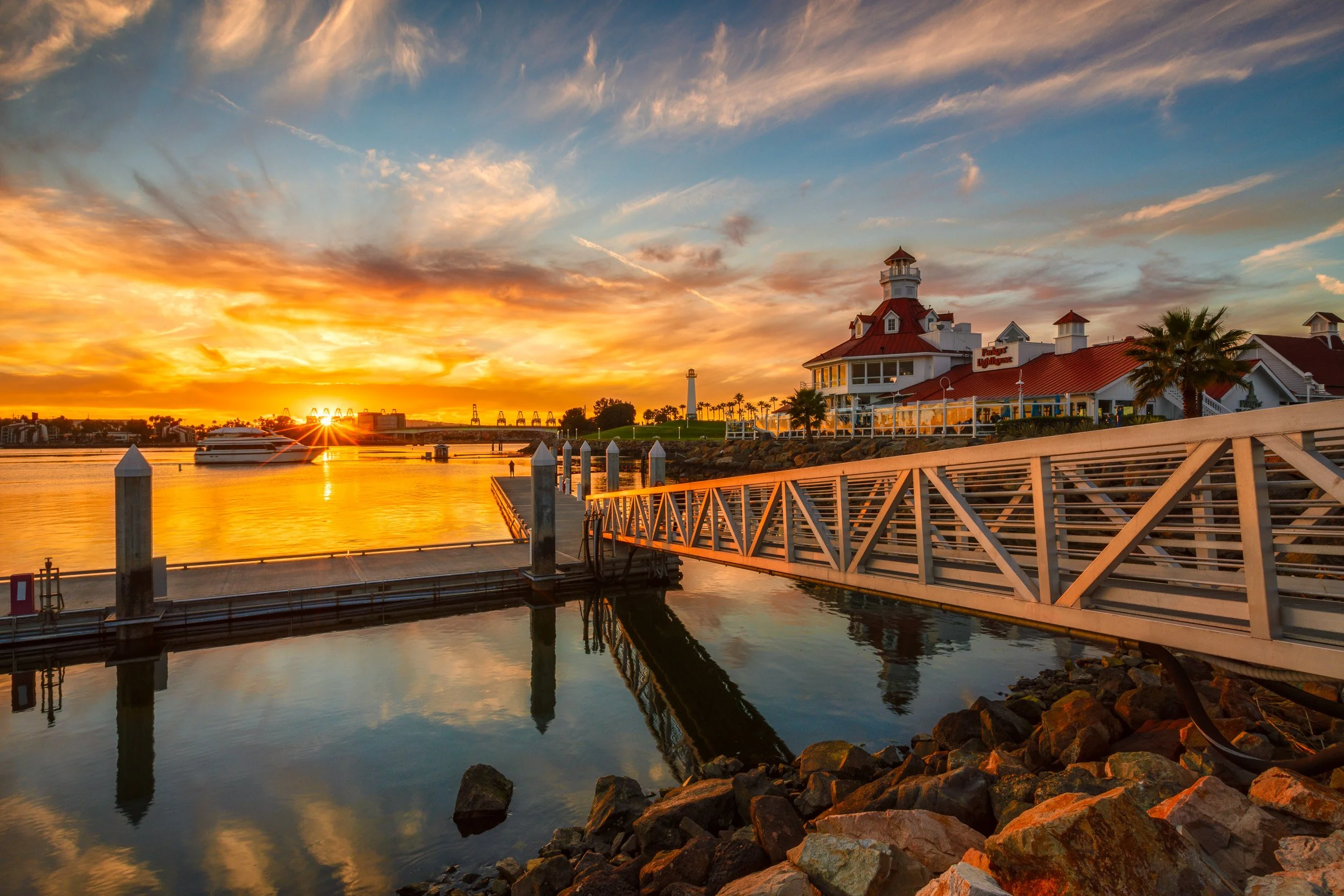 Vibrant golden sunset bursting over Shoreline Village marina and Parker's Lighthouse in Long Beach, California by Chris Ewen Crosby.