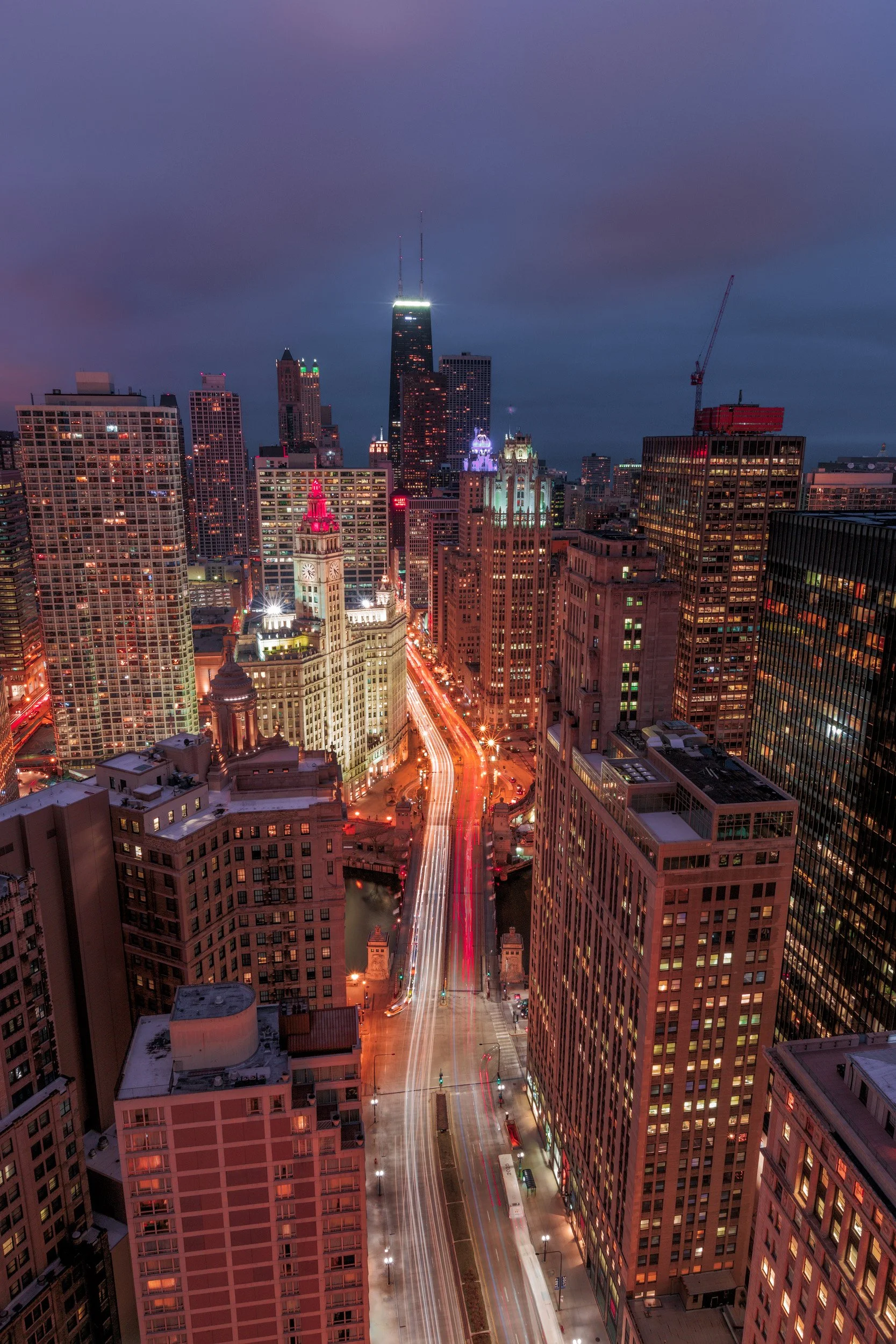 High-angle long exposure looking down Michigan Avenue at night toward the Wrigley Building and Chicago skyline by Chris Ewen Crosby.