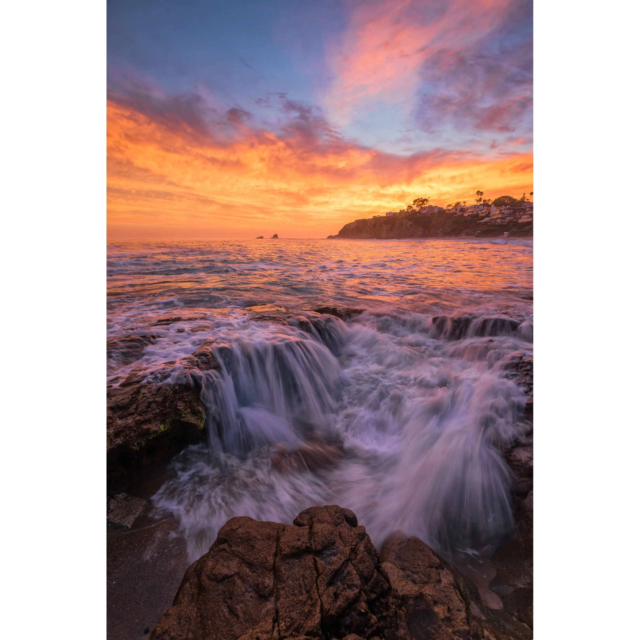 Vertical fine art photograph by Chris Ewen Crosby, featuring golden sunset skies and cascading water over tide pool rocks.
