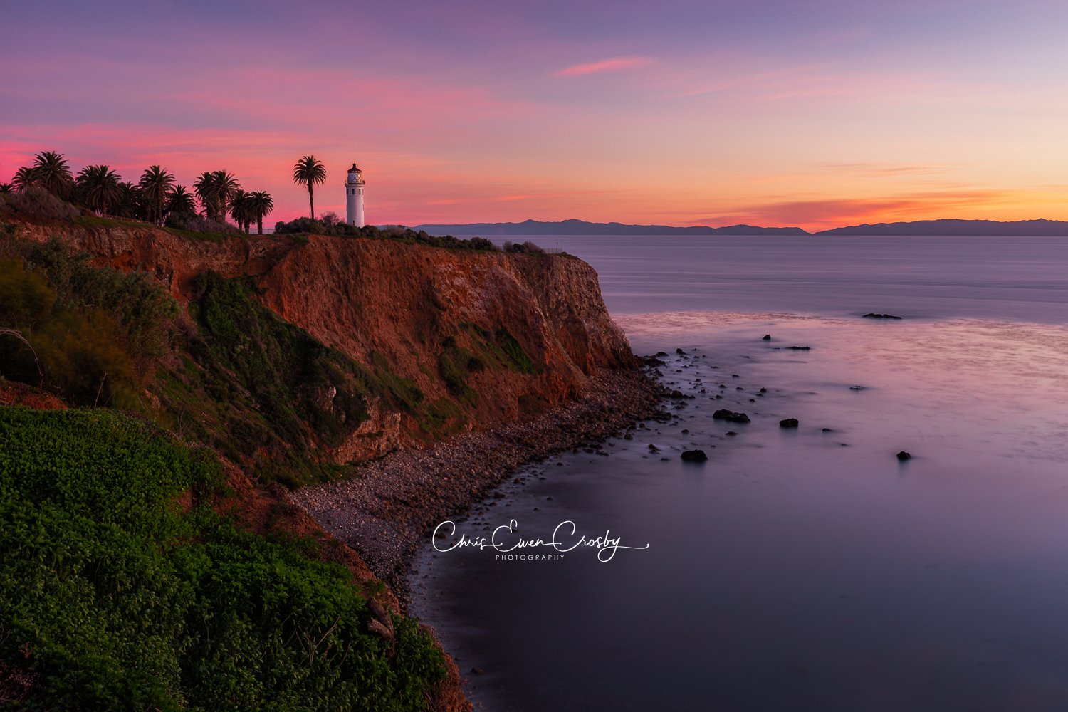 A horizontal landscape photo of the Point Vicente Lighthouse in Palos Verdes at sunset, with warm side lighting and a warm sunset.