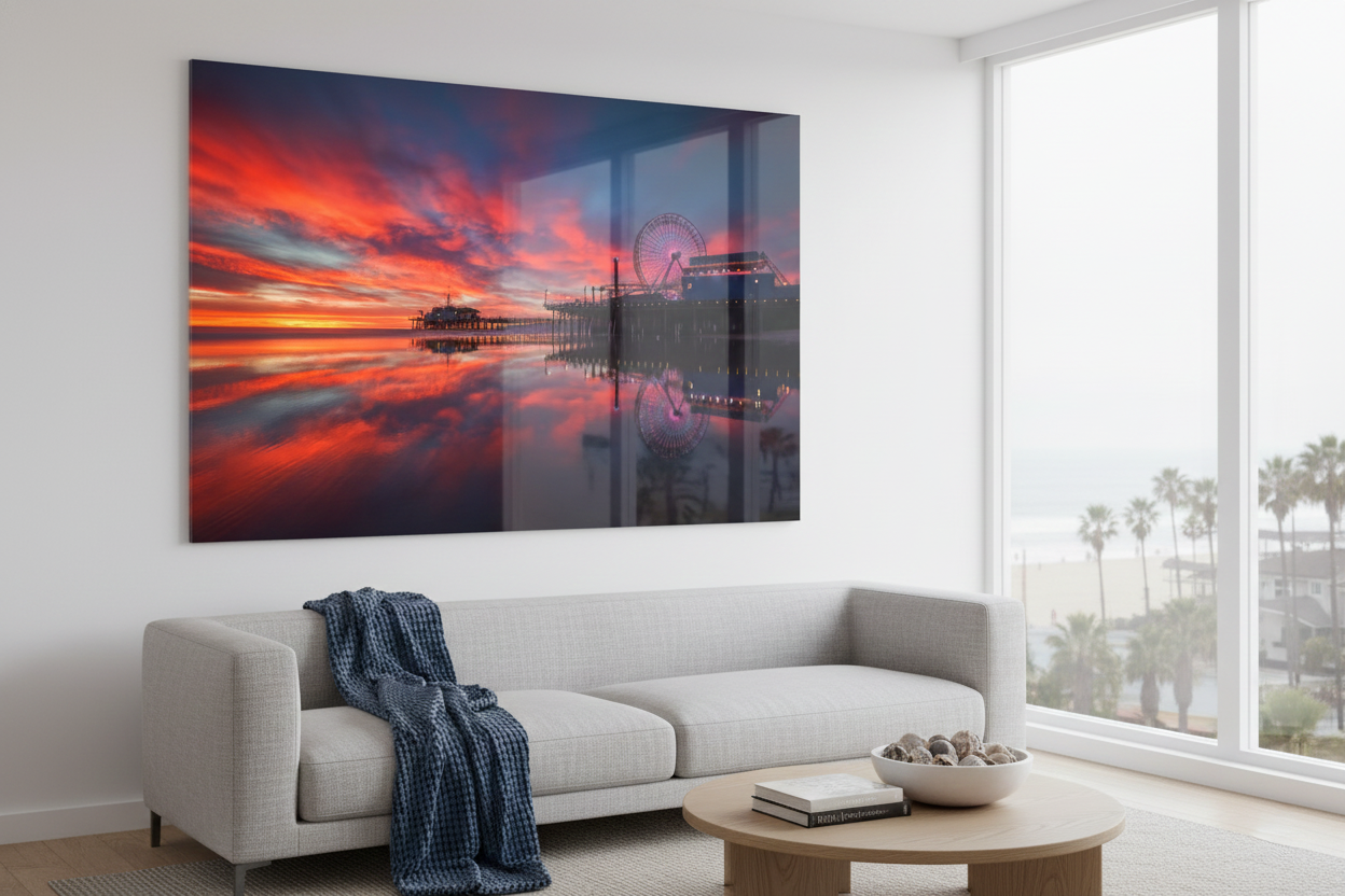 Large framed Santa Monica Pier print hanging in a modern coastal living room above a cream sectional couch.