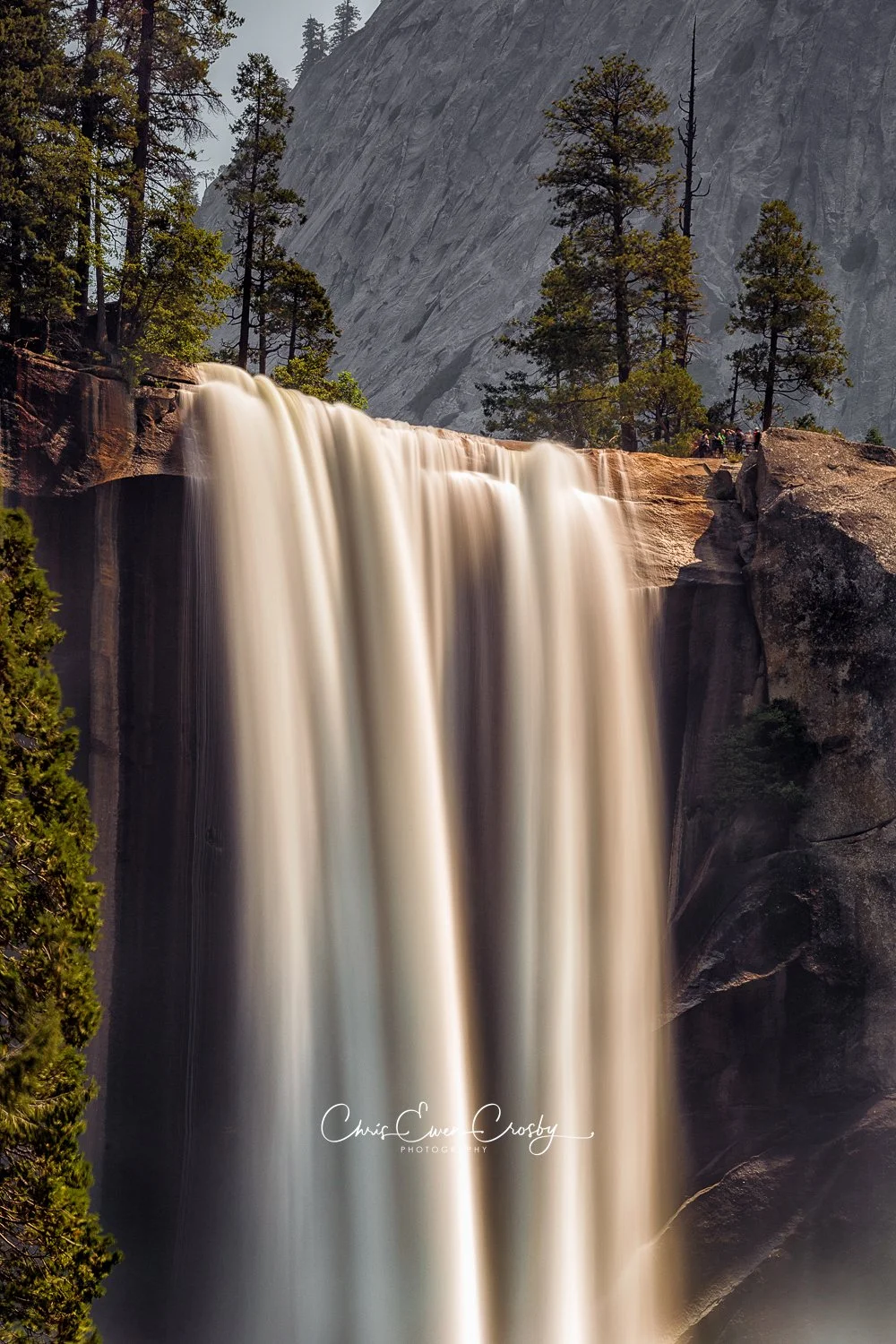 Vertical 2:3 long exposure of Vernal Fall in Yosemite National Park, showing silky white water over dark granite rocks.