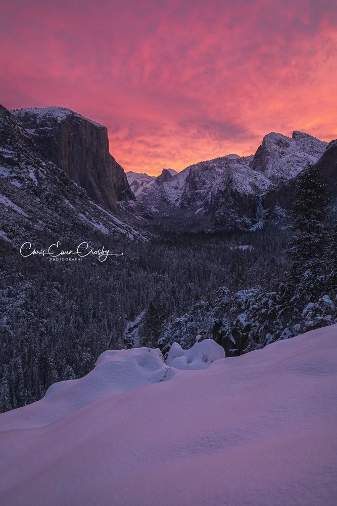 Vertical photography print of Yosemite Tunnel View at sunrise with vibrant pink and orange clouds over snow-covered mountains.