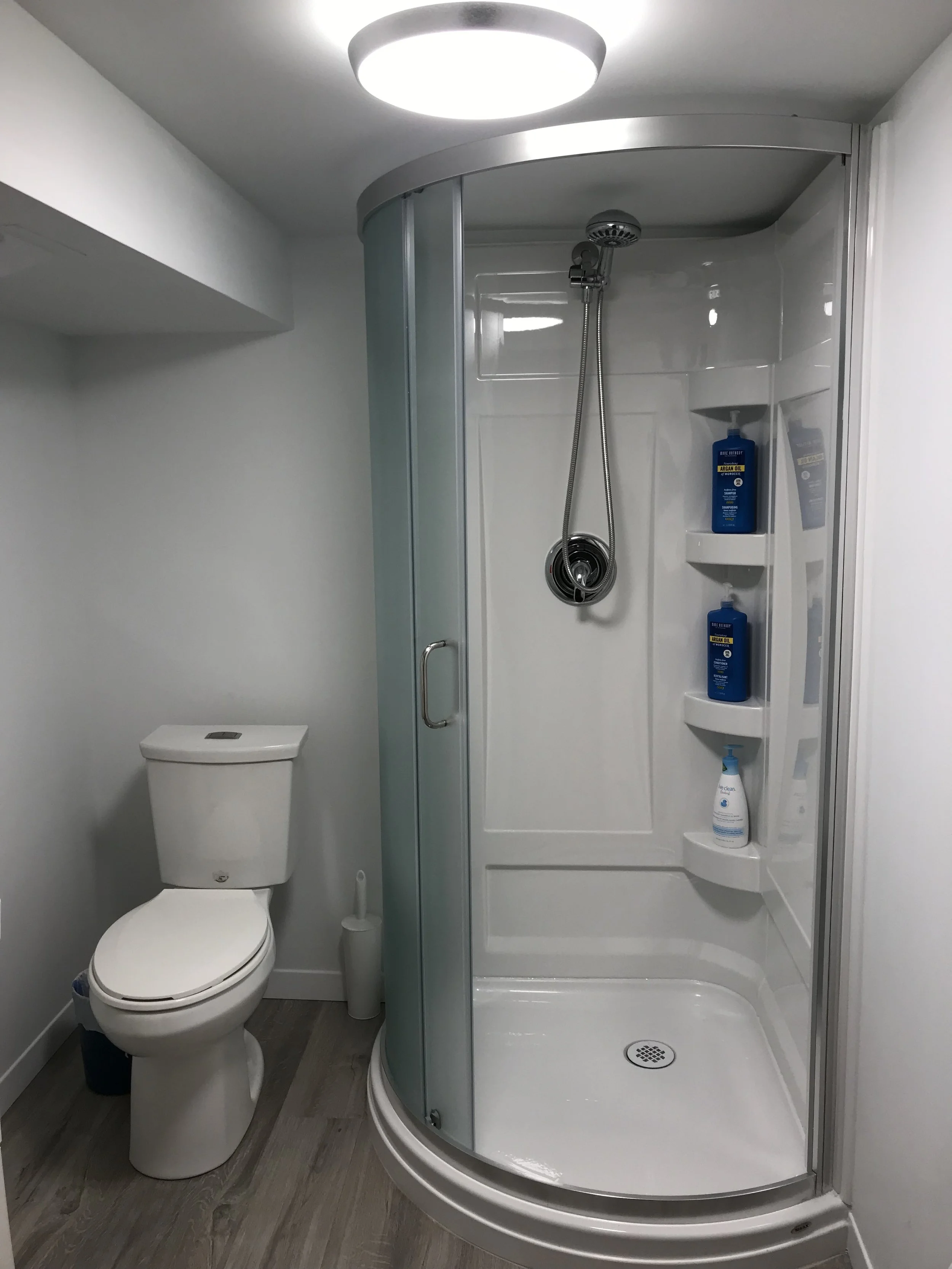 Bathroom after plumbing, wall, floor levelling, new fixtures, and electrical fixes