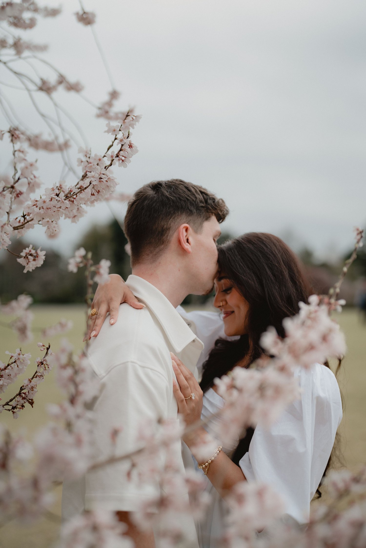 A couple framed by cherry blossoms