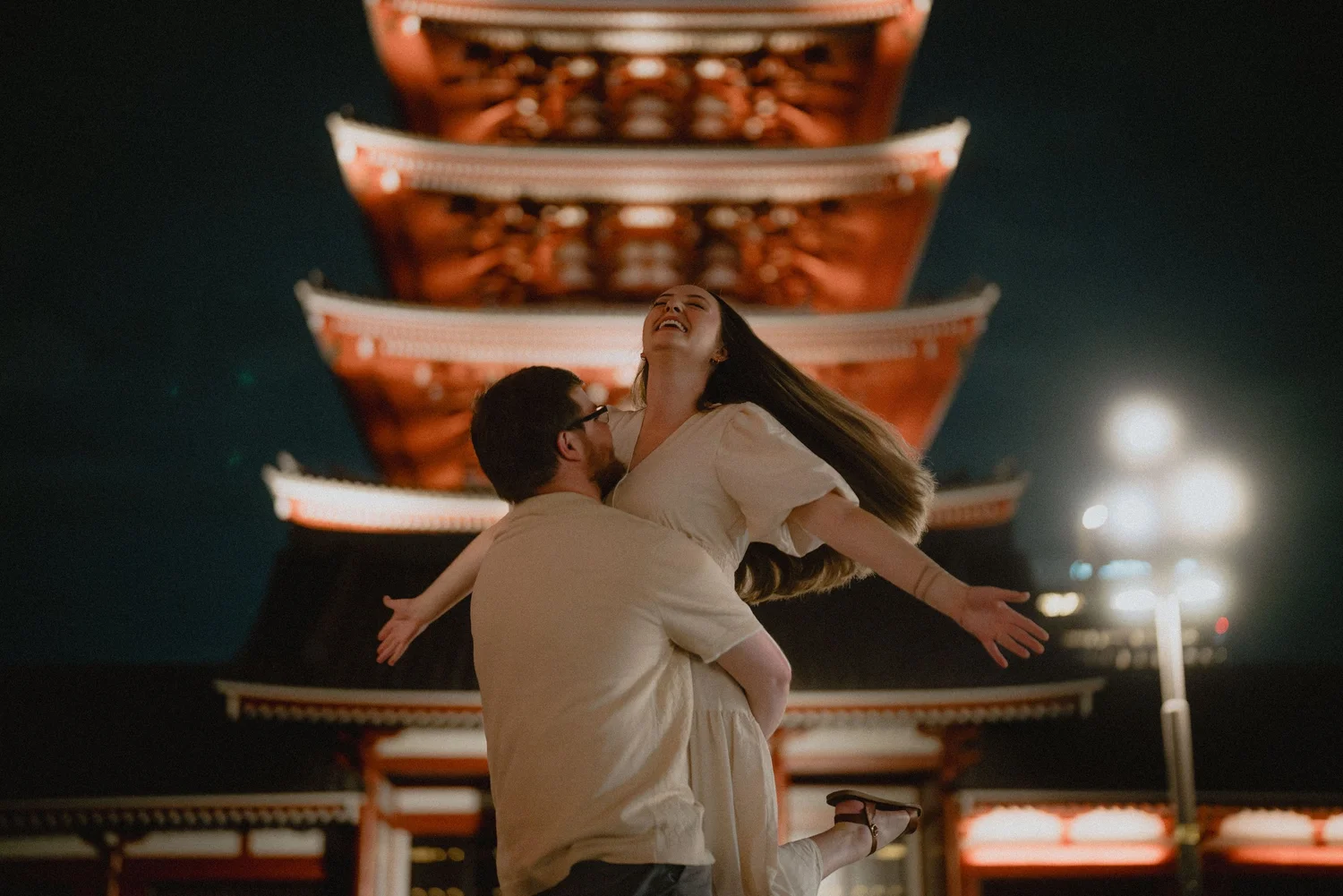 A playful couple photographed at night in Tokyo