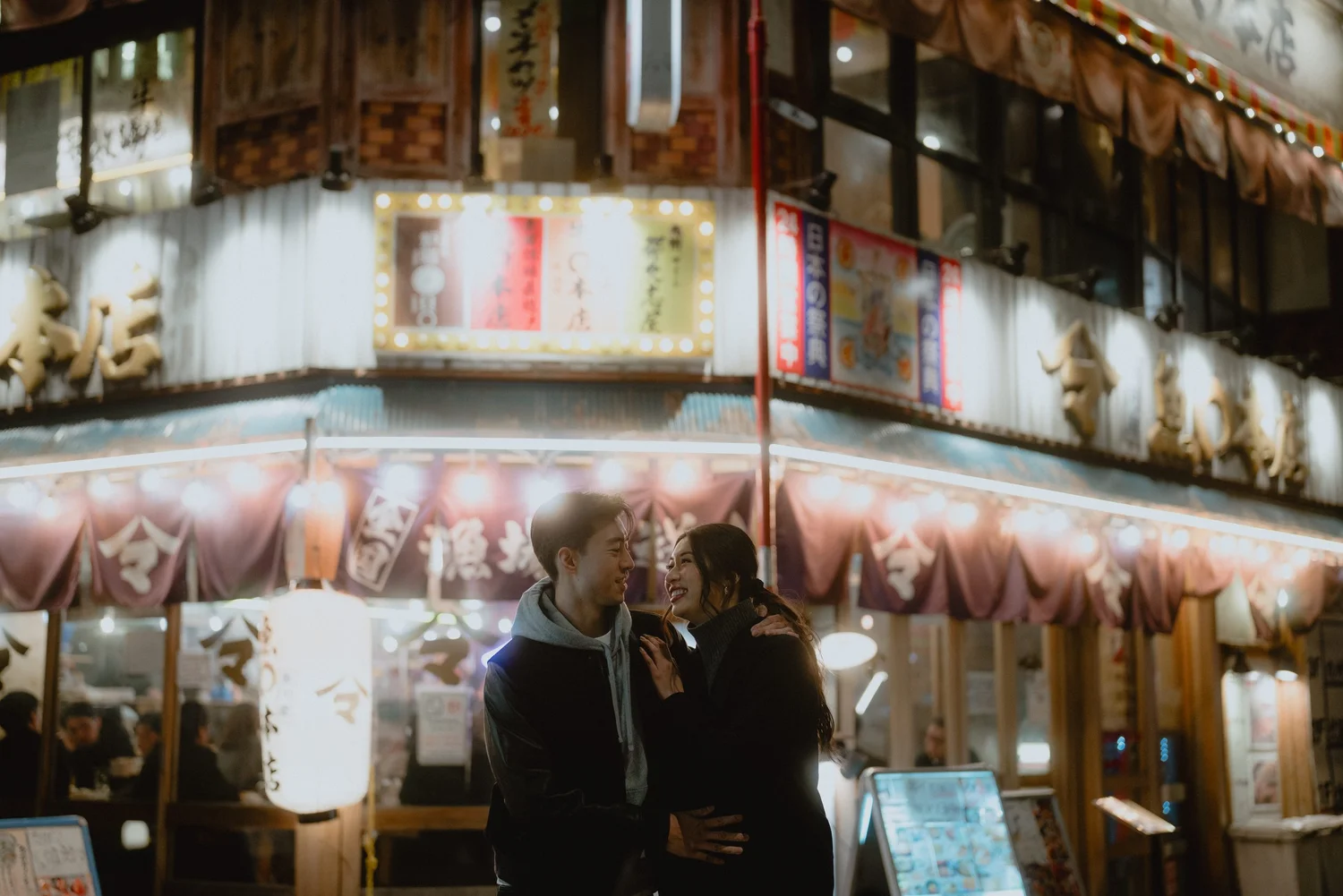 A couple laughing together in Tokyo at night