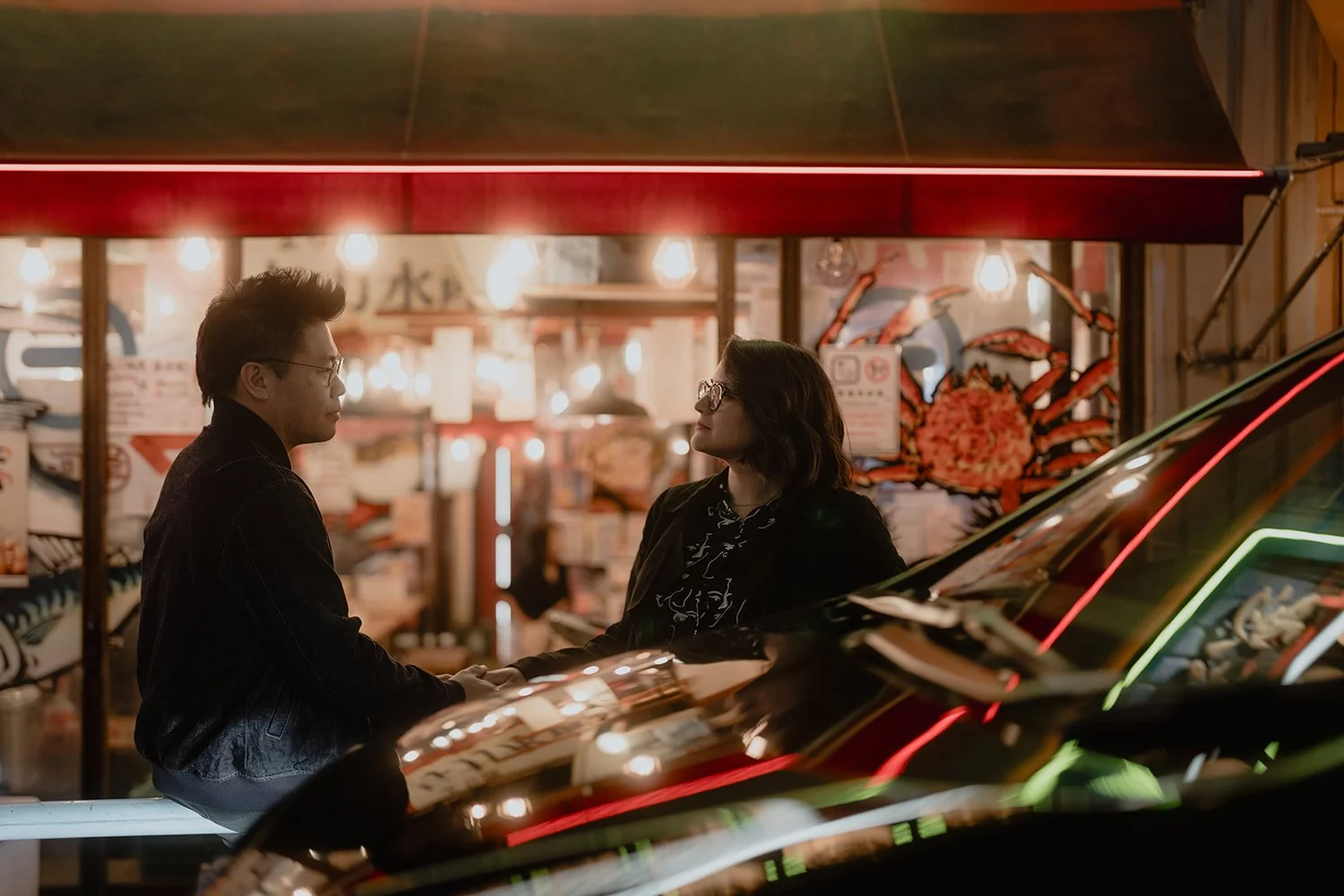 A couple photographed among Tokyo lights at night