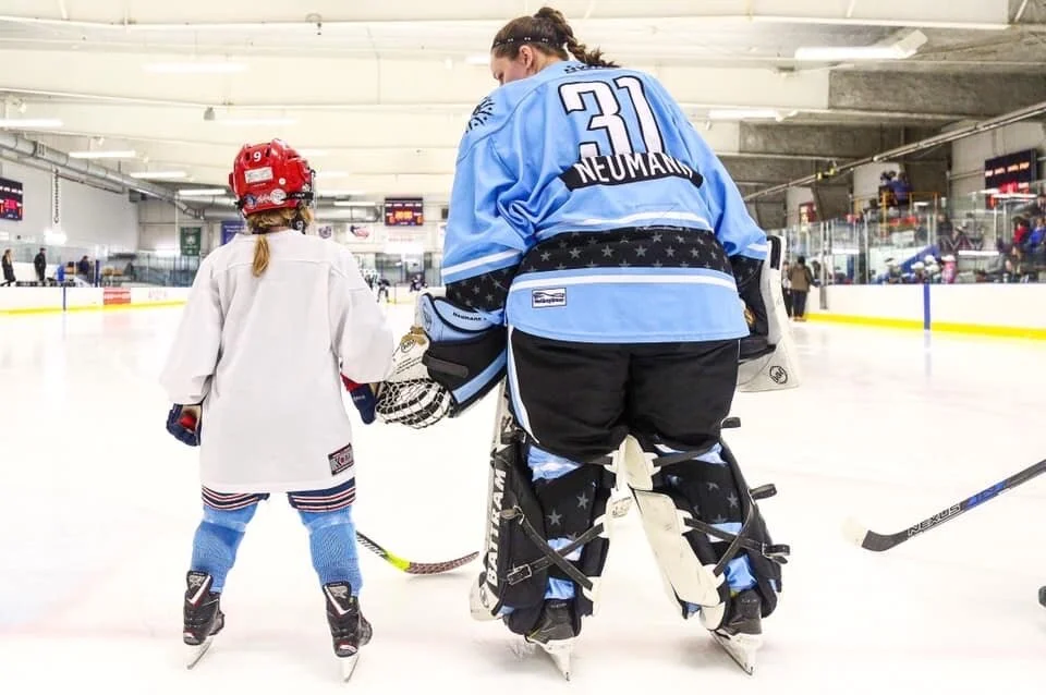 Neumann on the ice in Buffalo with one of her youngest students.
