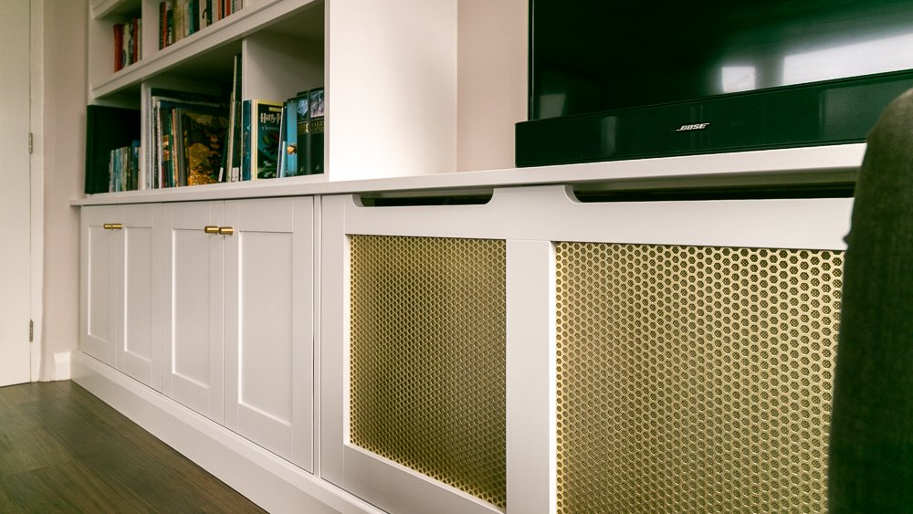 Painted bookcase with gold anodised radiator grille and TV