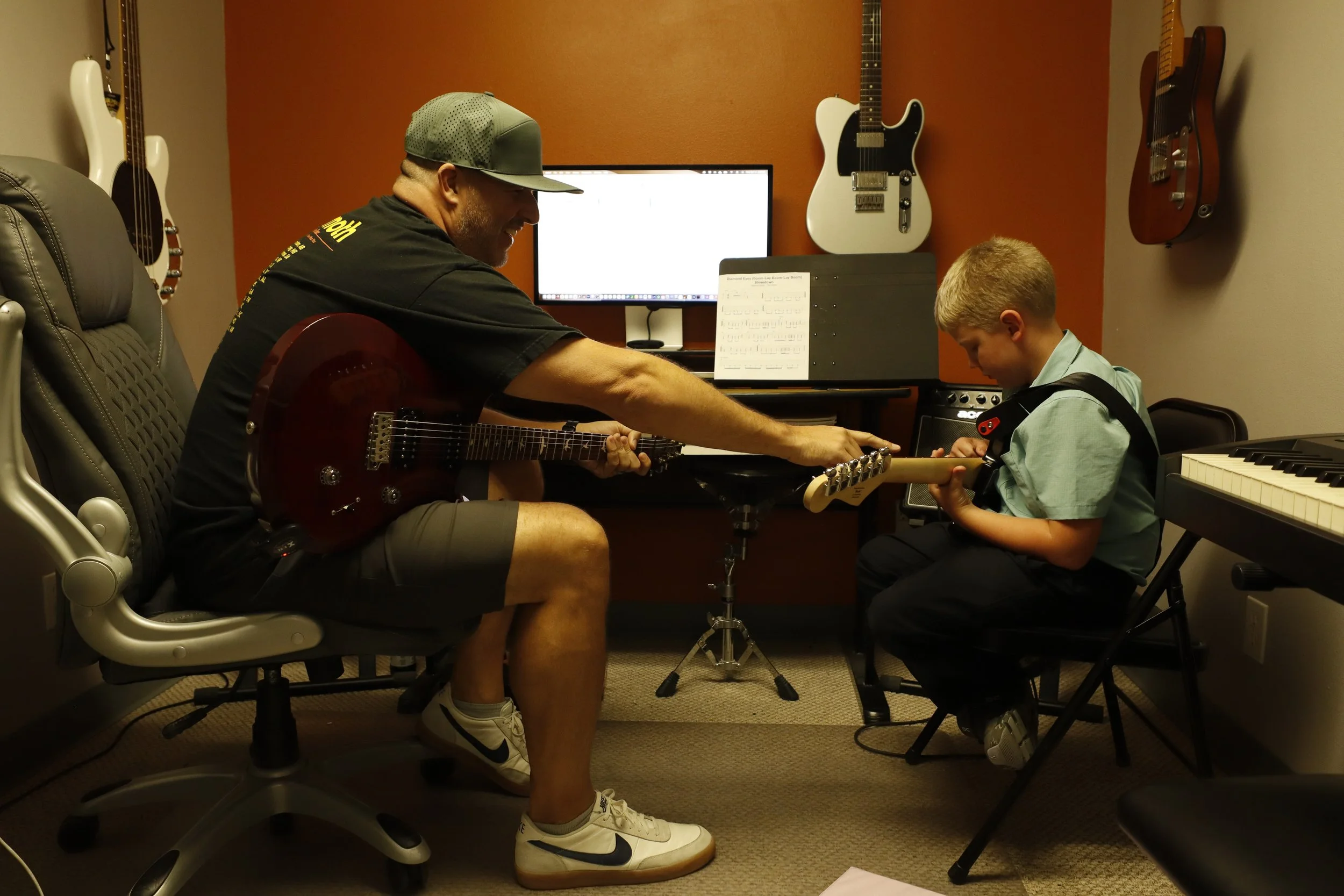 Dustin Baird helping a student with guitar at Sumner Lesson Studios.