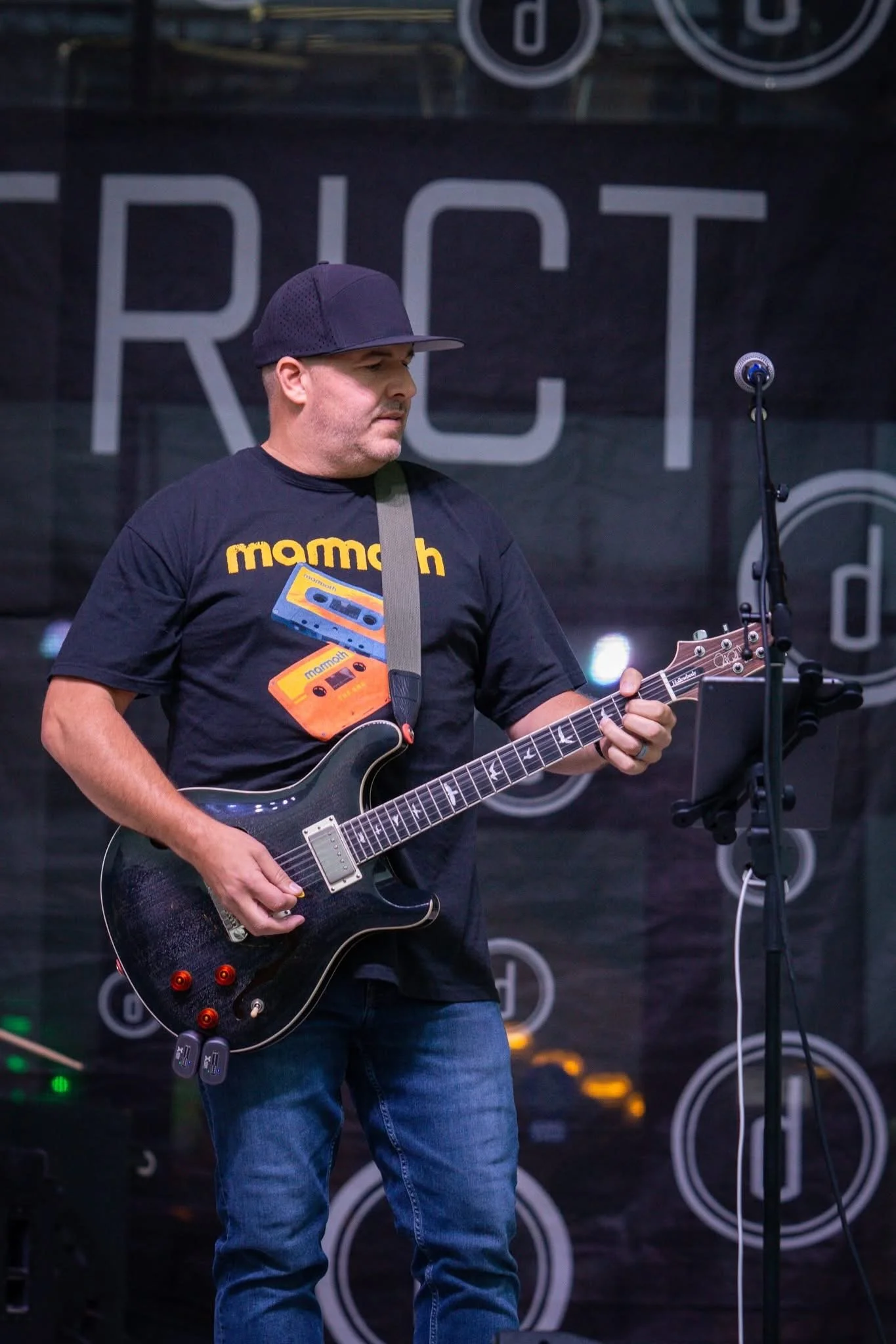 Dustin Baird playing electric guitar on stage.