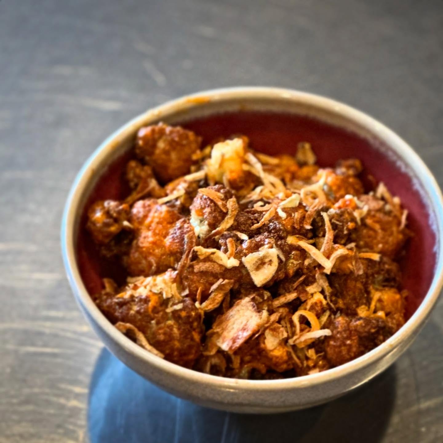 So simple. So humble. So delicious. We flash fry unadorned cauliflower till it&rsquo;s golden and concentrated before tossing it with a cashew cream and house made hot sauce. It&rsquo;s finished with our own unique umami crunch. A real show stopper!