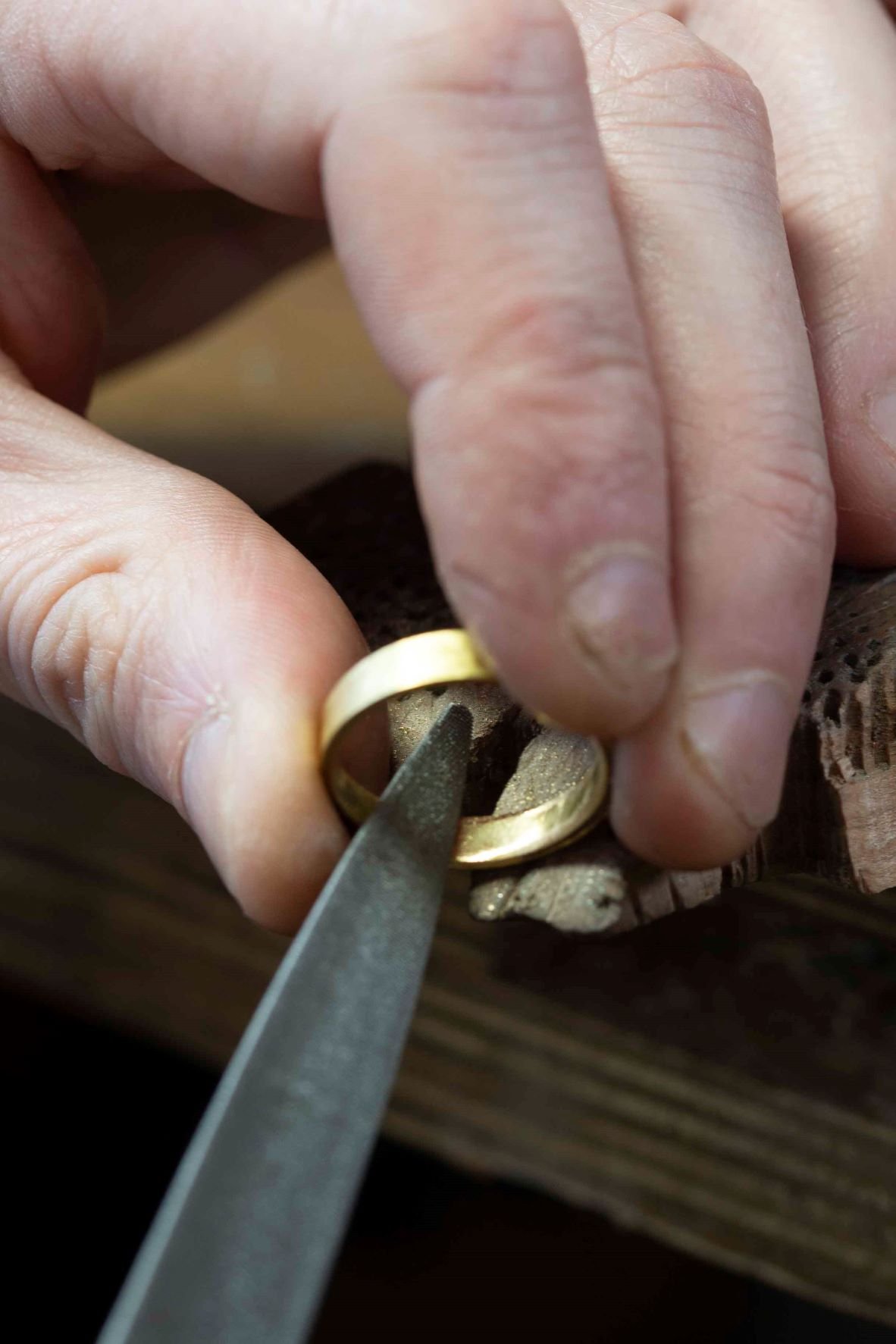 A jeweller making a gold wedding ring