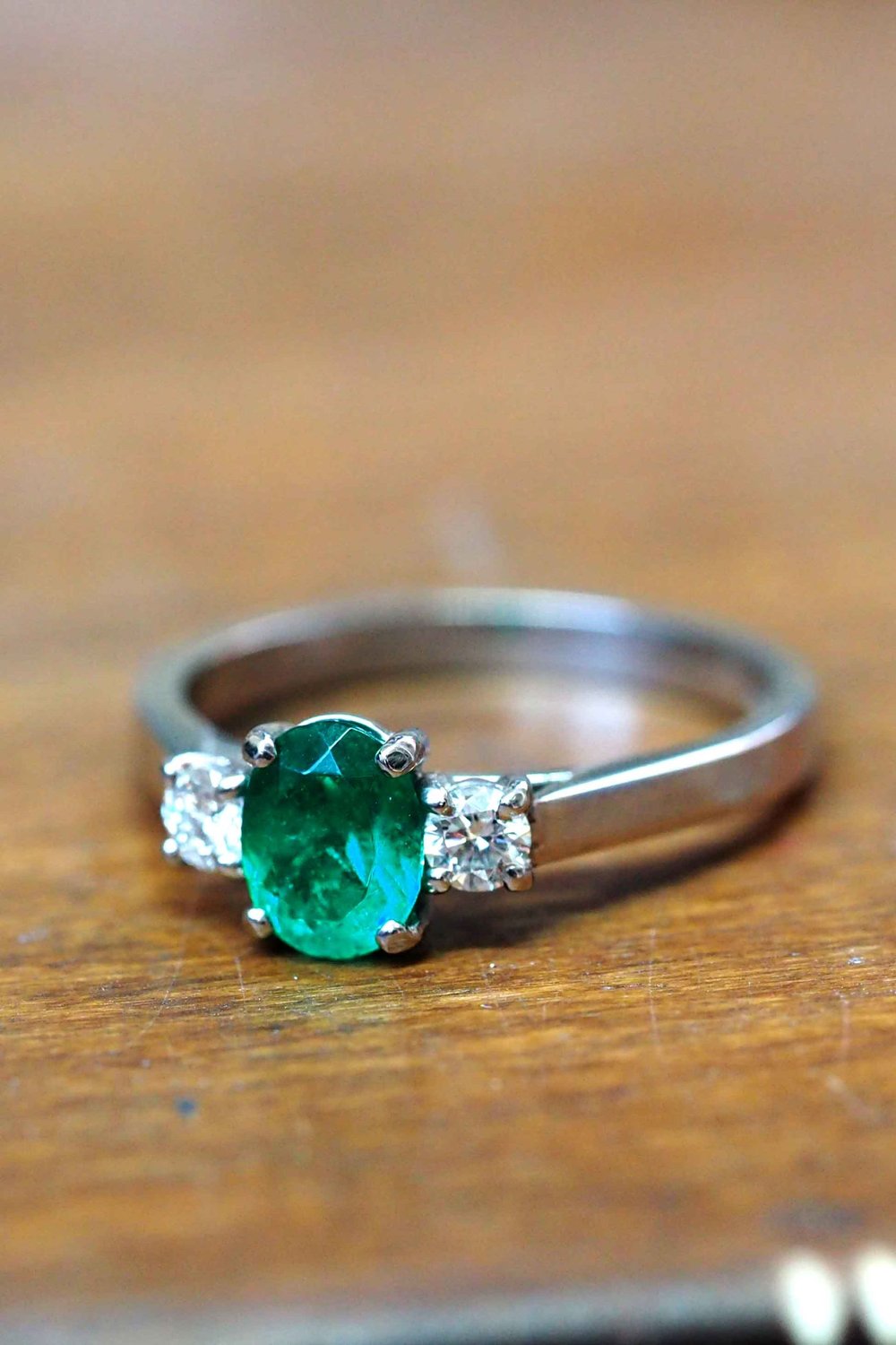 0.53ct oval cut emerald and 0.16ct total weight diamond ring in platinum. —  Edward Fleming Jewellery