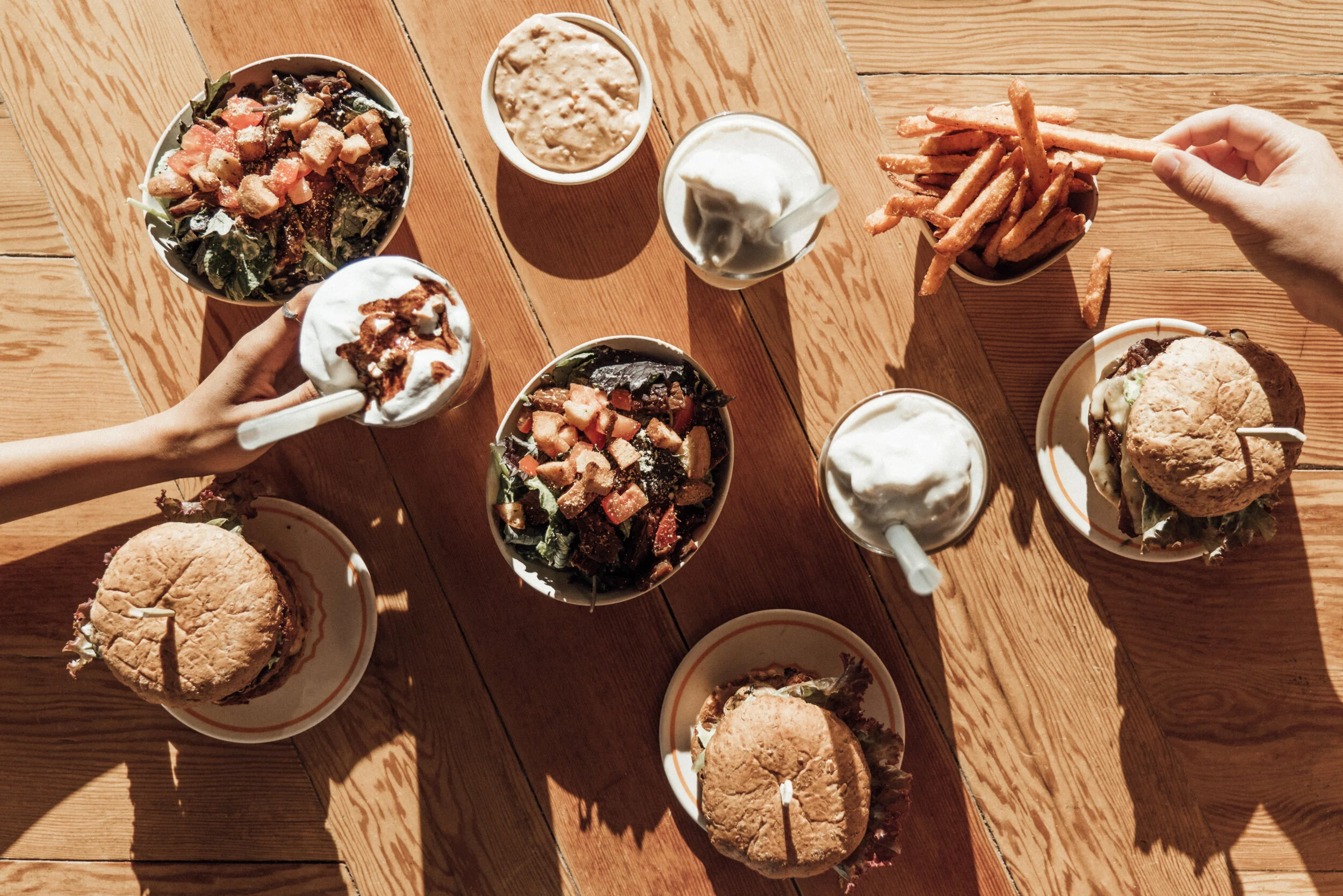 Classic Burger, SoCal Burger, and All American Burger with Kale Caesar Salads, Sweet Potato Fries, a Dark Chocolate PB Cup Milkshake, and Peach Milkshakes.