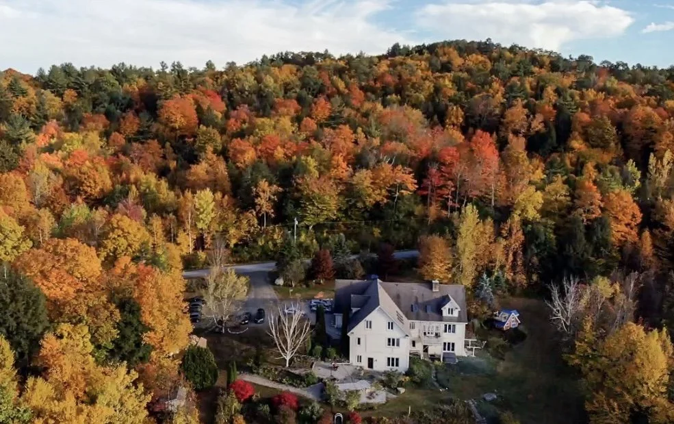 Aerial fall view of Setu Vermont retreat center with colorful autumn foliage.