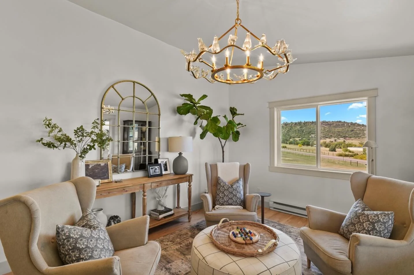 Loving the final results of this living room space! Four chairs around a round ottoman creates the perfect conversation spot, while layers and patterns add visual interest. The bold, dark display cabinets bring a striking contrast and offer beautiful
