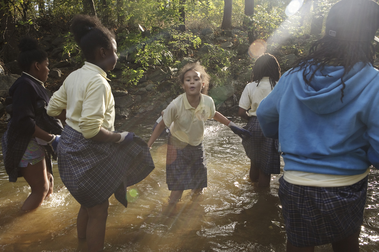  A group of girls take part in a trash clean up in a creek outside Town Hall Education Arts Recreation Campus in southeast D.C. 