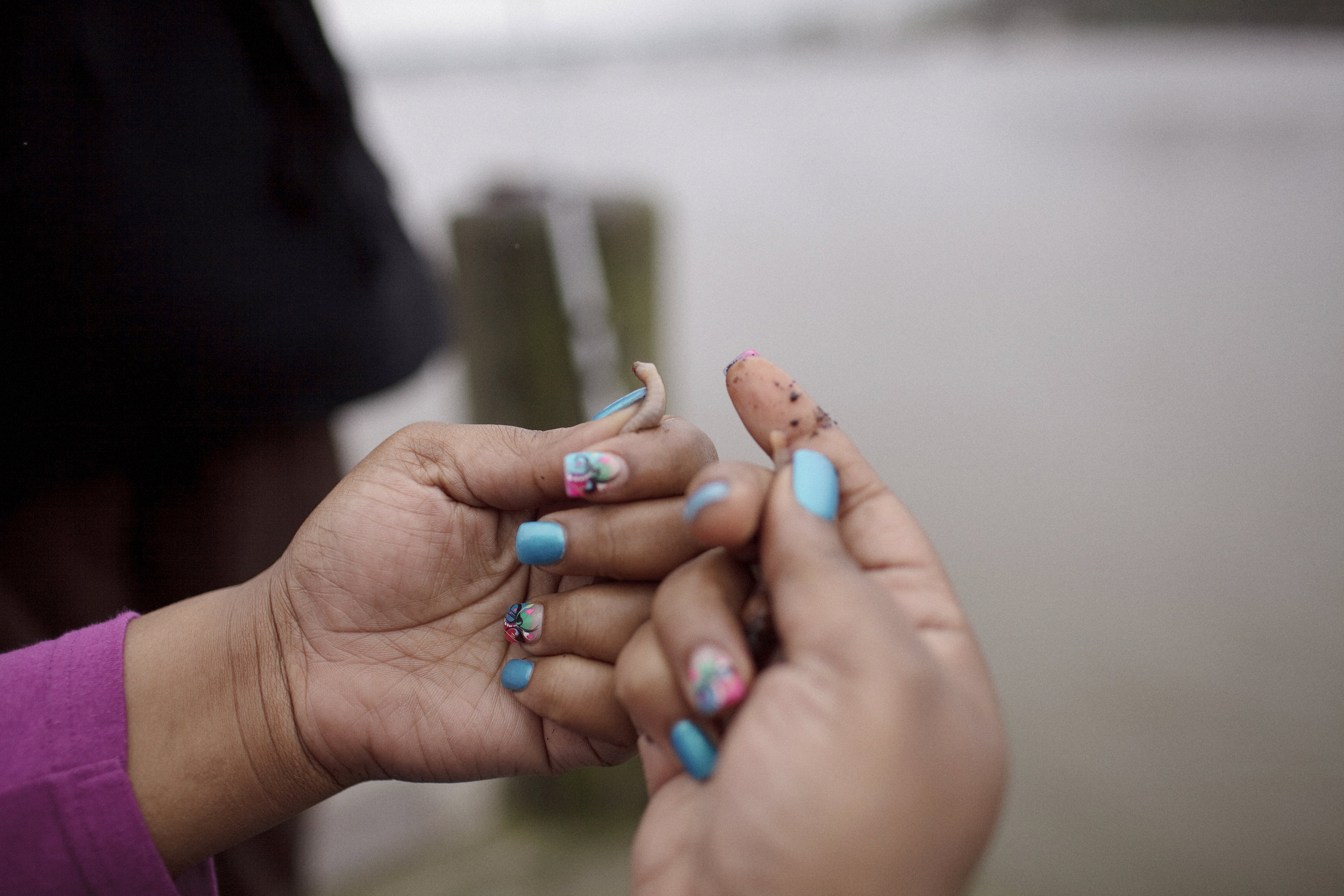 A woman baits a hook for fishing at the boat ramp in Anacostia Park. She and her family were fishing recreationally. There are many who do not consume the fish because they are aware of the conditions of the water.