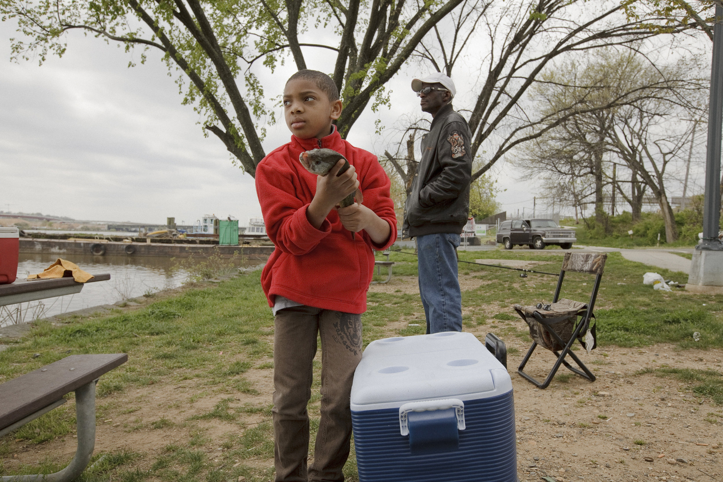  Elijah holds a caught fish just south of the John Philip Sousa Bridge on a Sunday afternoon in April. He was fascinated by the fish that his dad and his friends caught. 
