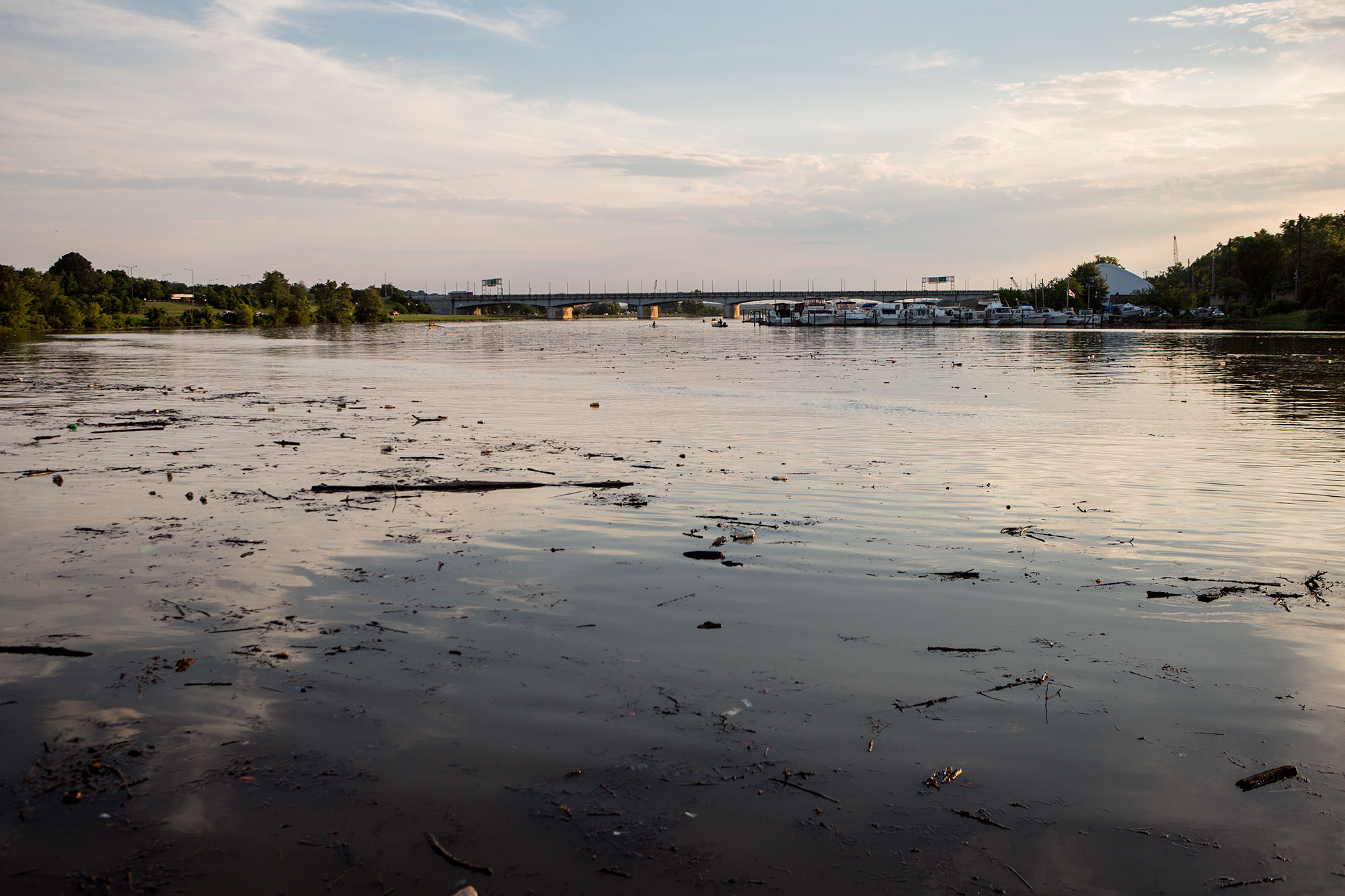  A quiet evening view of the Anacostia River in 2017 after a heavy rain, which stirred up debris in the river. The Seafarers clubhouse and the Pennsylvania Avenue bridge appear in the distance. 