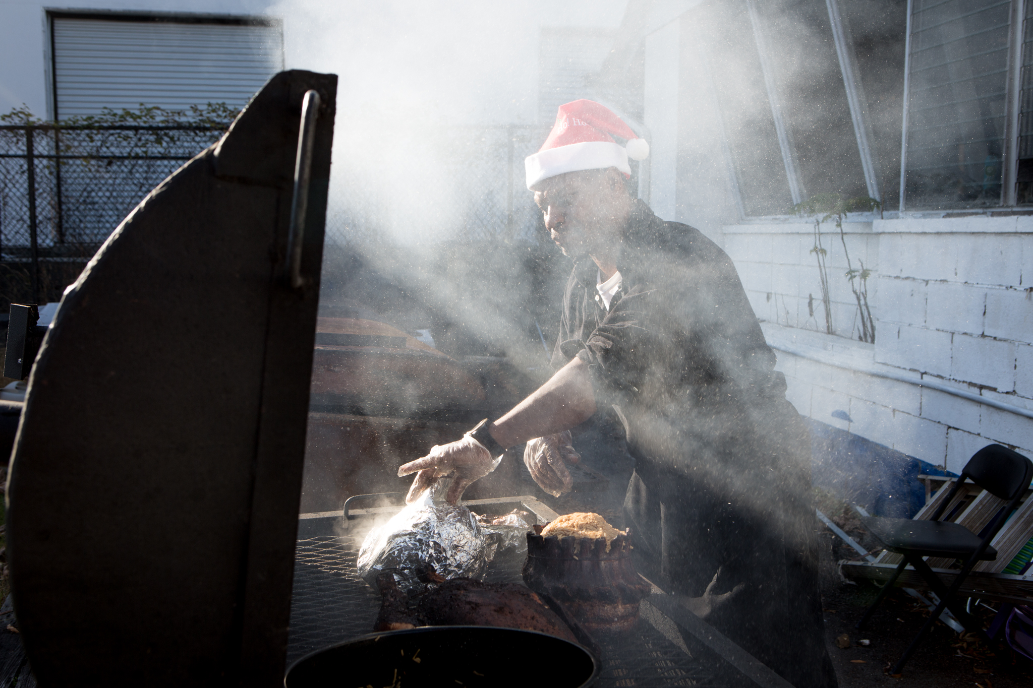  Wearing a Santa Claus hat, Maurice Marshall runs the grill at a Thanksgiving celebration in 2015. 