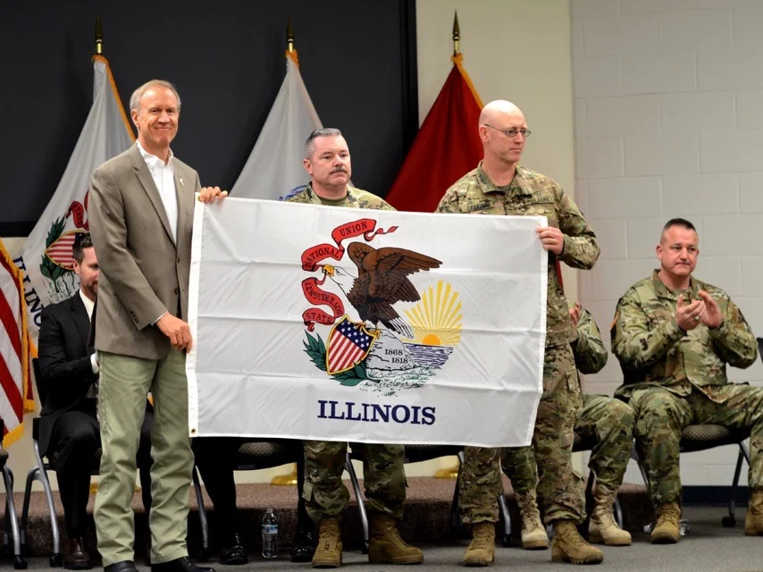 Gov. Bruce Rauner sends off National Guard troops to Afghanistan with an Illinois flag in 2016. (Illinois National Guard Public Affairs Office)