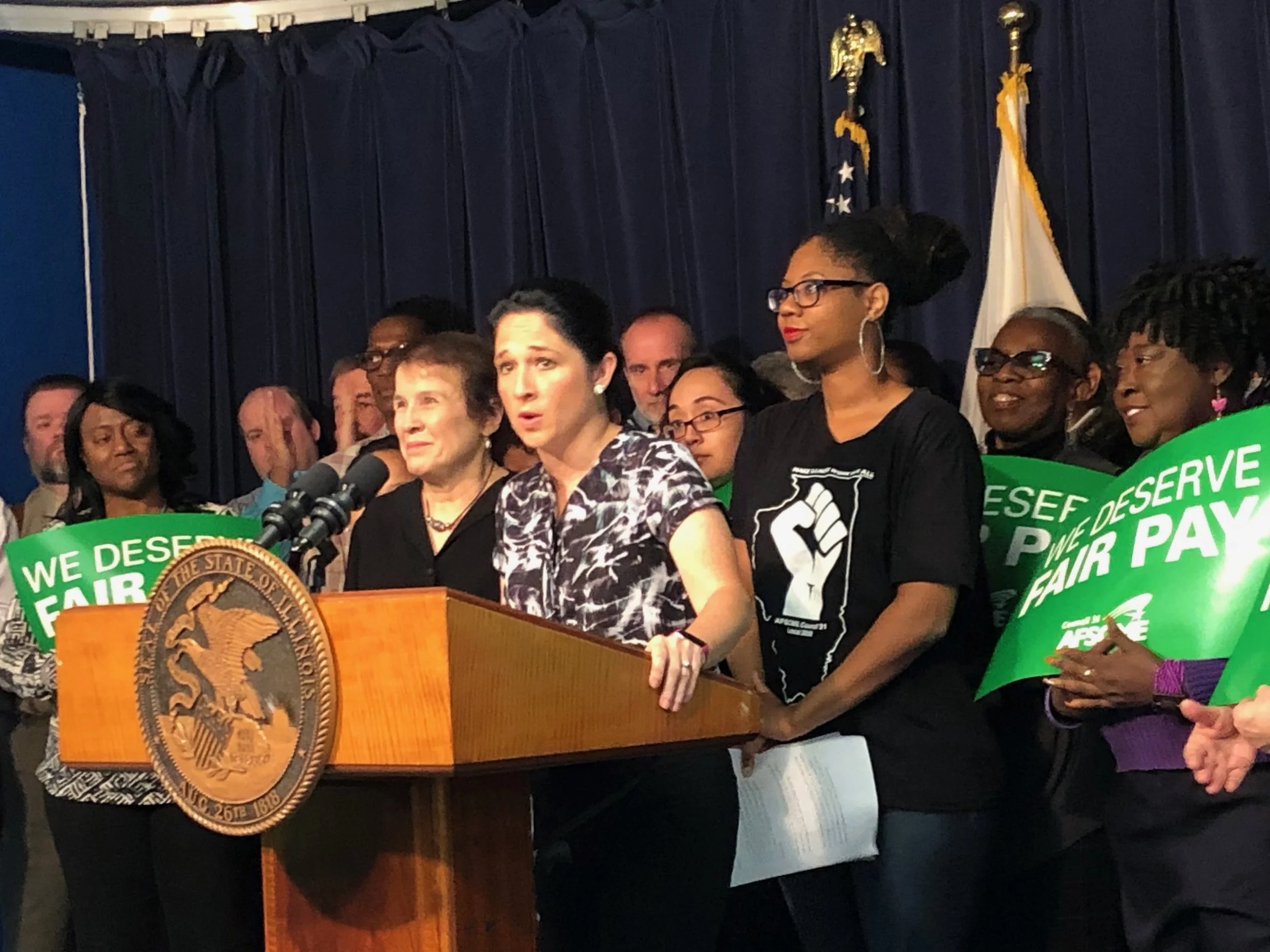 Flanked by AFSCME Council 31 Executive Director Roberta Lynch and state worker Brittany Adams, Comptroller Susana Mendoza lays into Gov. Rauner Thursday at the Thompson Center. (One Illinois/Ted Cox)