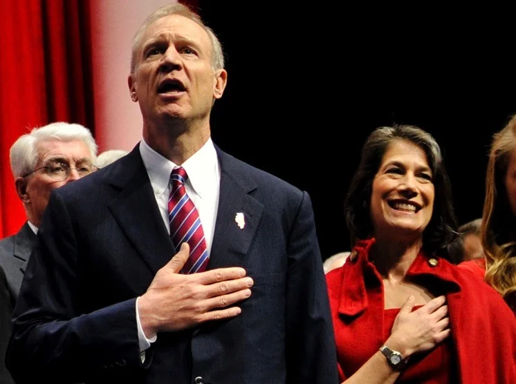 Gov. Bruce Rauner and his wife, Diana, sing the national anthem at an event. (U.S. Air National Guard/Staff Sgt. Lealan Buchrer)