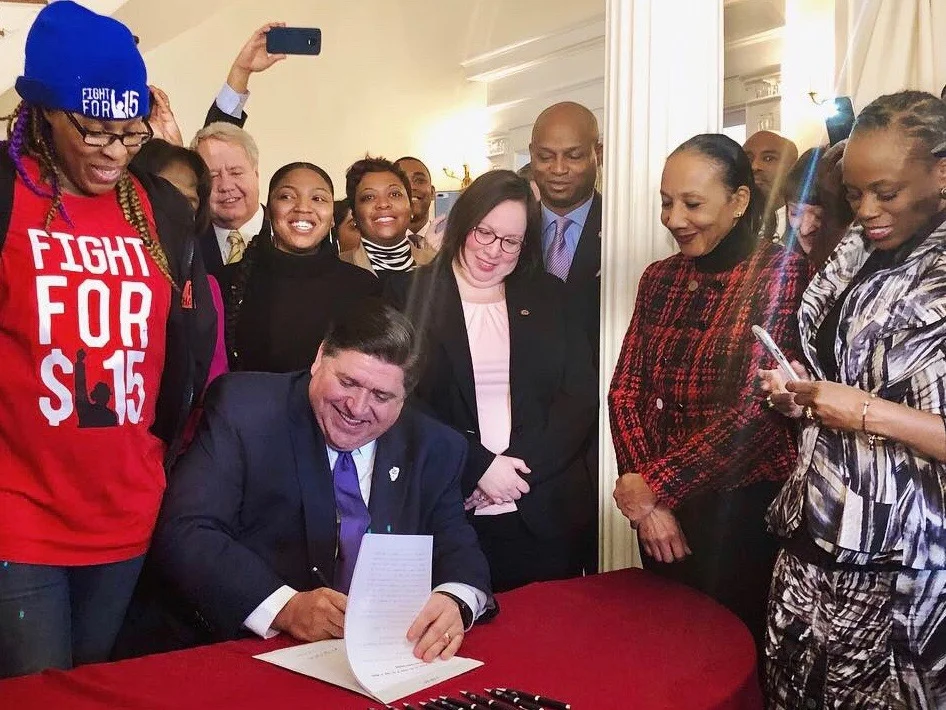Gov. J.B. Pritzker signs a $15-an-hour minimum wage into law at the Governor’s Mansion Tuesday. (Twitter/GovPritzker)