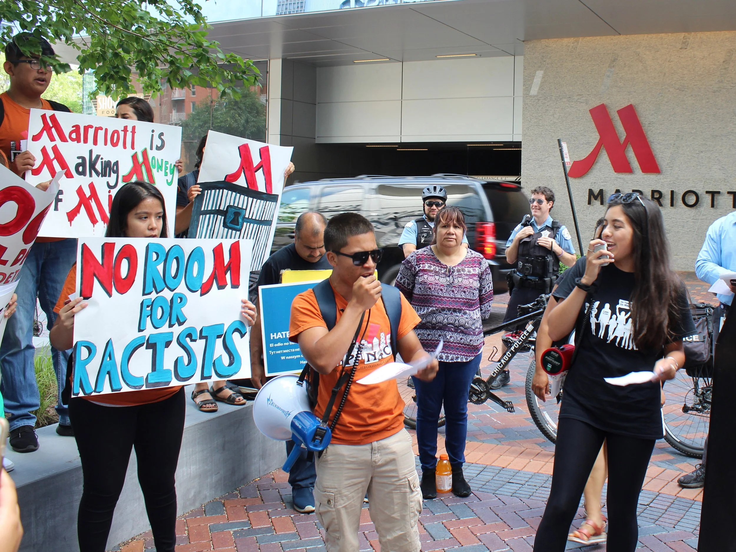 Tatiana Munoz (right) leads protesters at the Customs and Border Protection trade symposium outside the Marriott Marquis in Chicago. (One Illinois/Ted Cox)