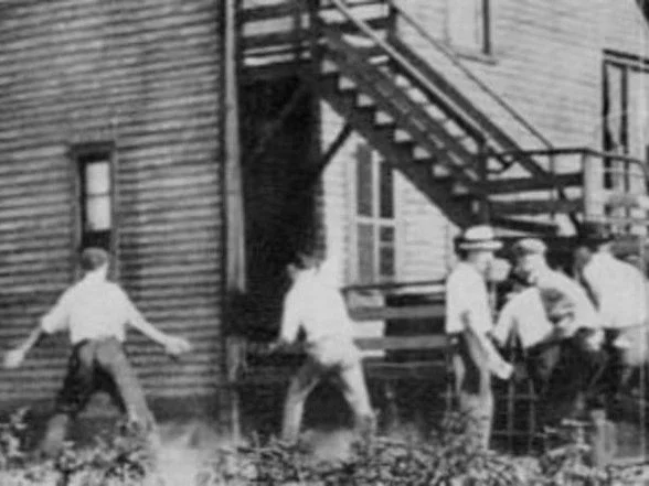 A white mob brandishes stones in pursuit of someone unseen during the 1919 Chicago race riots. The photo is in the public domain, although the Chicago History Museum credits it to Jun Fujita.