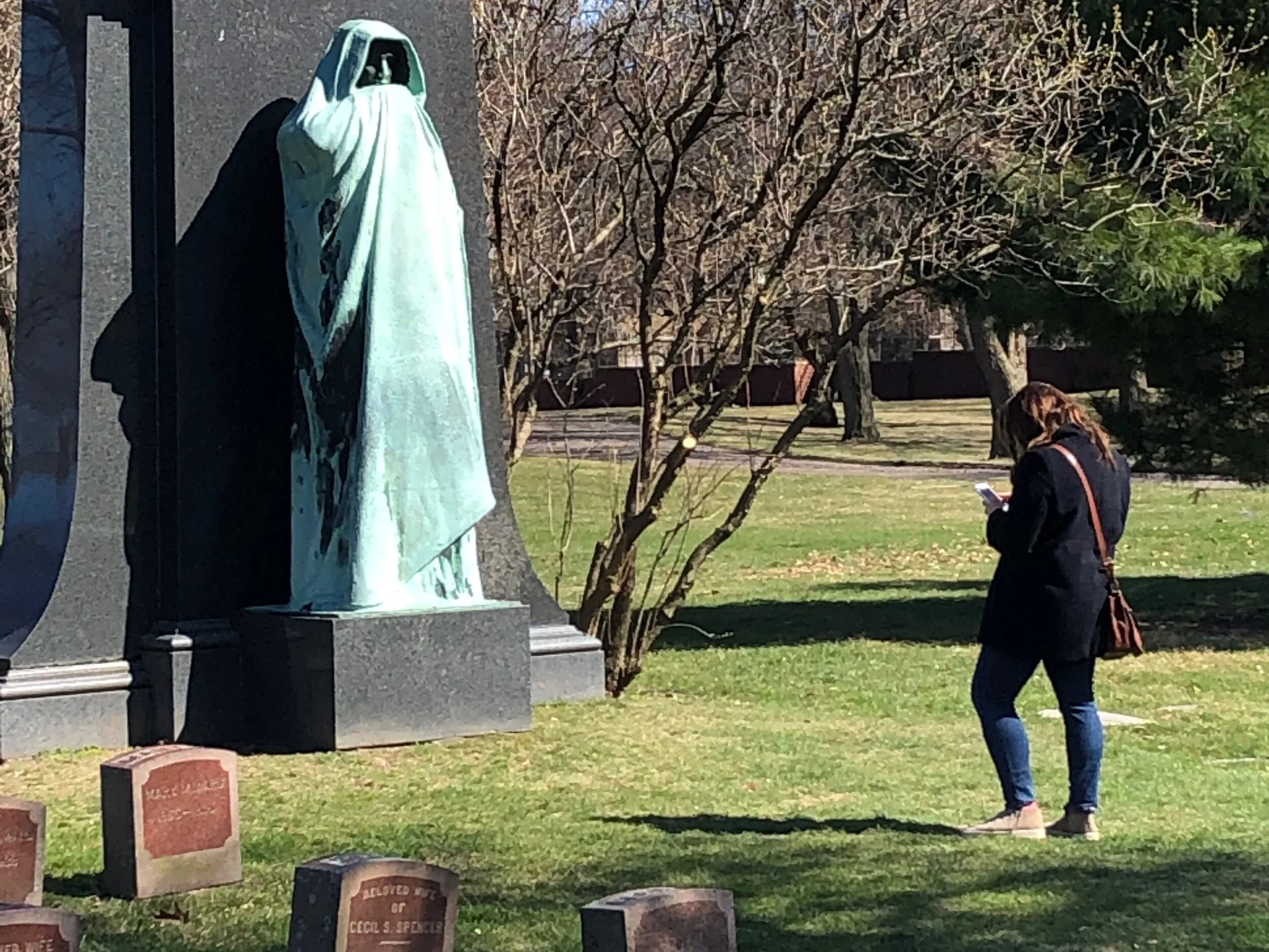 Lorado Taft’s sculpture “Eternal Silence” attracts a masked visitor during the coronavirus pandemic at Chicago’s Graceland Cemetery. (One Illinois/Ted Cox)
