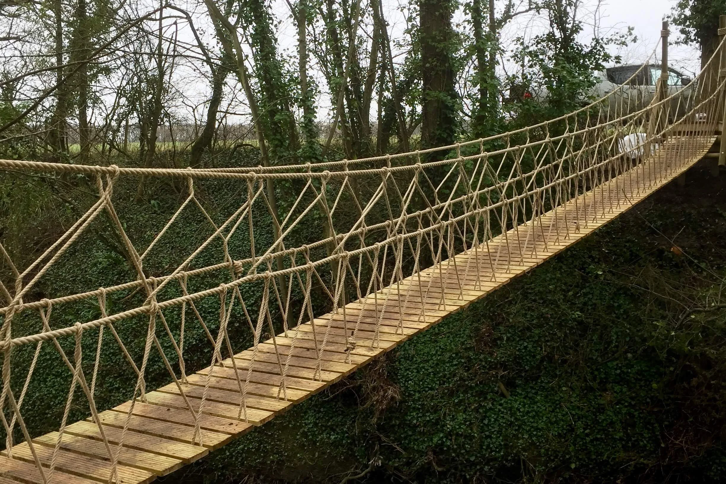 Rope Bridge suspended in woodland over river